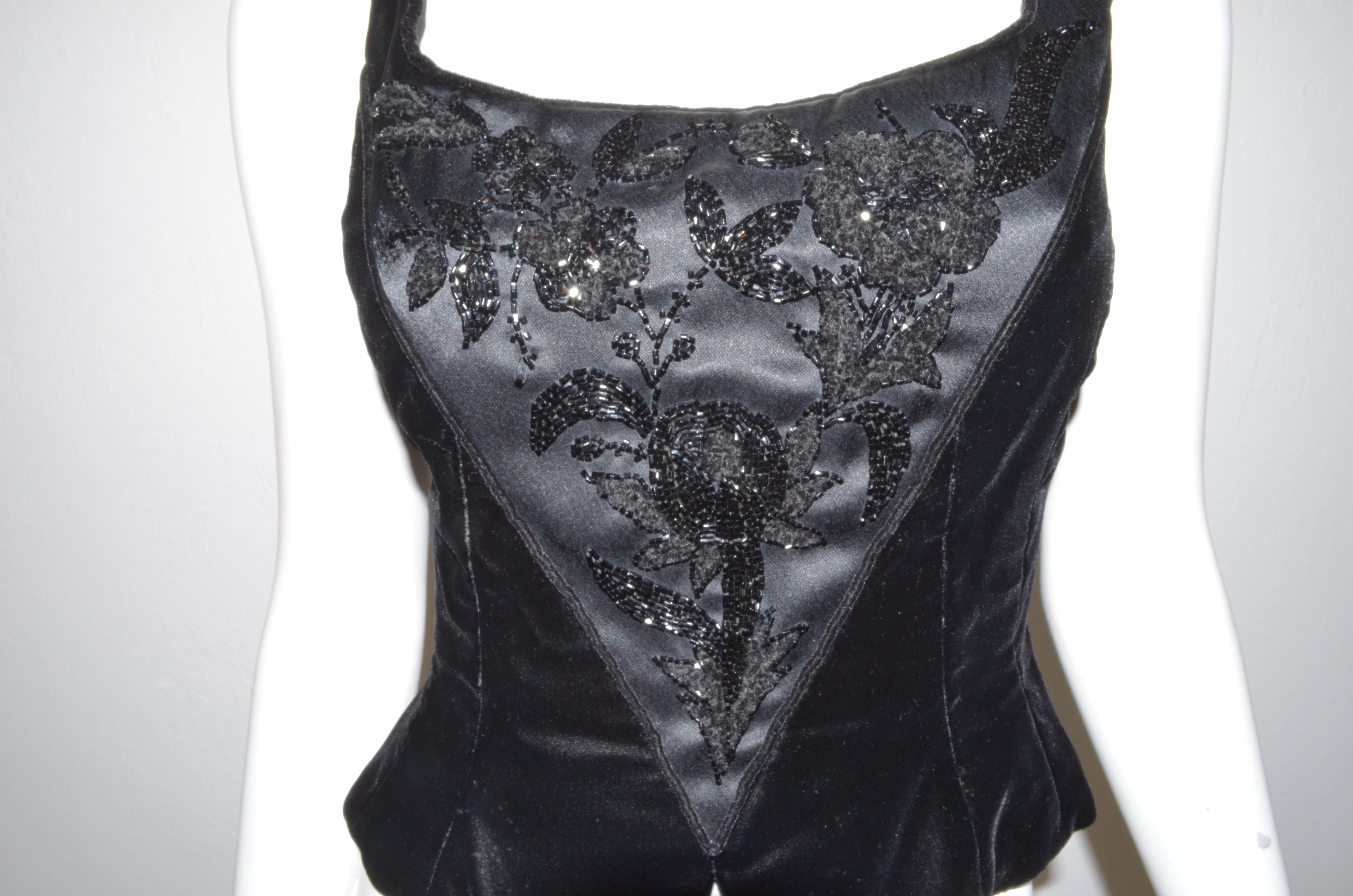 Vintage corset top featured in black velvet with bead embellishing at the front and a zipper back closure. Designer label has been removed, size 4 -- Top is composed with 65% acetate and 35% rayon, crepe: 75% triacetate, 25% polyester.