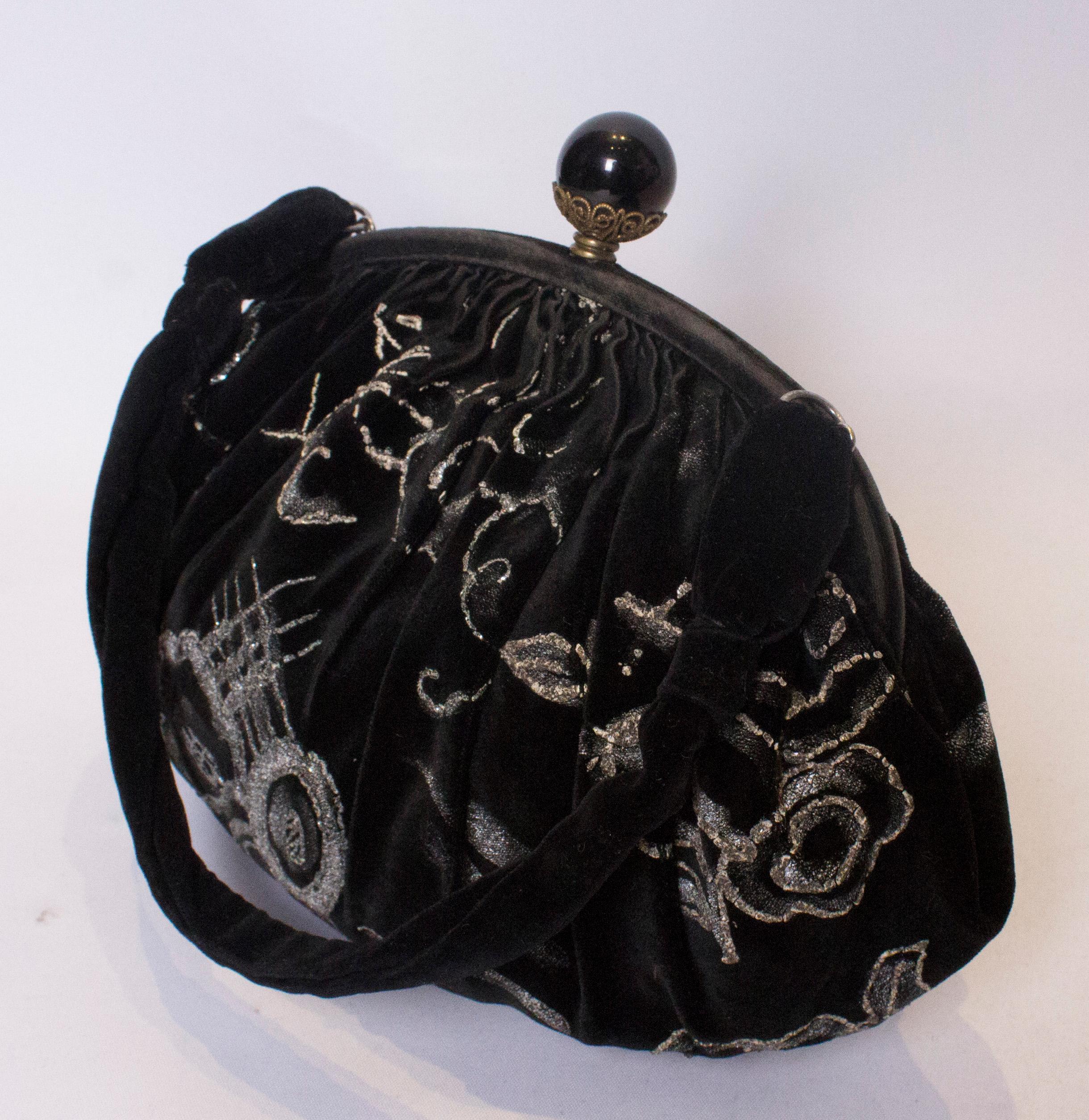 
A stunning black velvet handbag dating from the 1920s. The bag is black velvet with silver decoration. It has a decorative central top opening and is fully lined.
Measurements; width 11'', height 8'', depth 3''