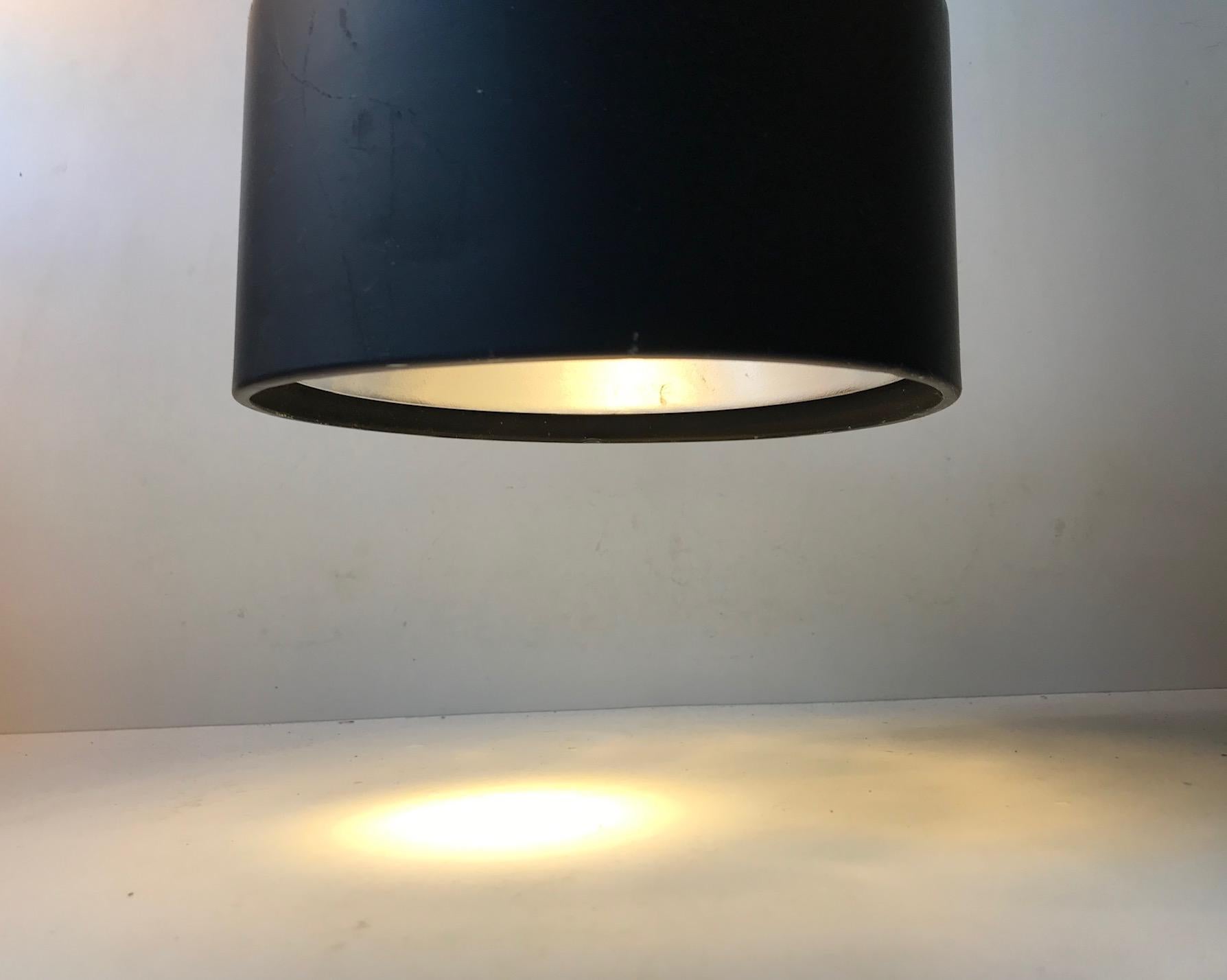 Adjustable wall lamp made from black powder-coated steel and aluminum. It features a porcelain socket and reflective inner shade. It was manufactured and designed in-house at Louis Poulsen in Denmark during the 1970s.