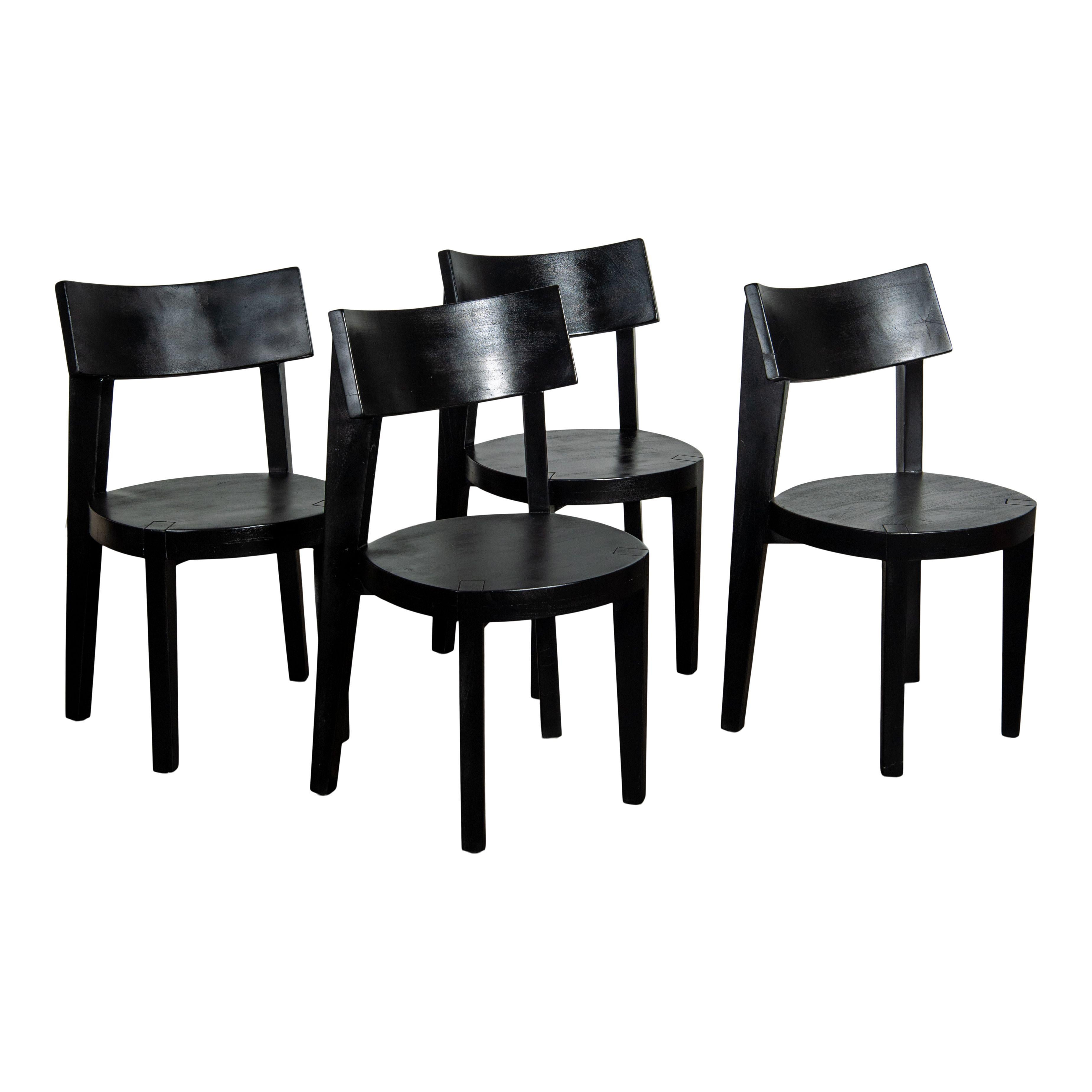 A beautiful set (4) of black wood dining chairs. The back of the chair is rounded and tilted, making it comfortable and stylish. The seat is also round and features expertly constructed joints that connect the legs, a small detail that adds lots of