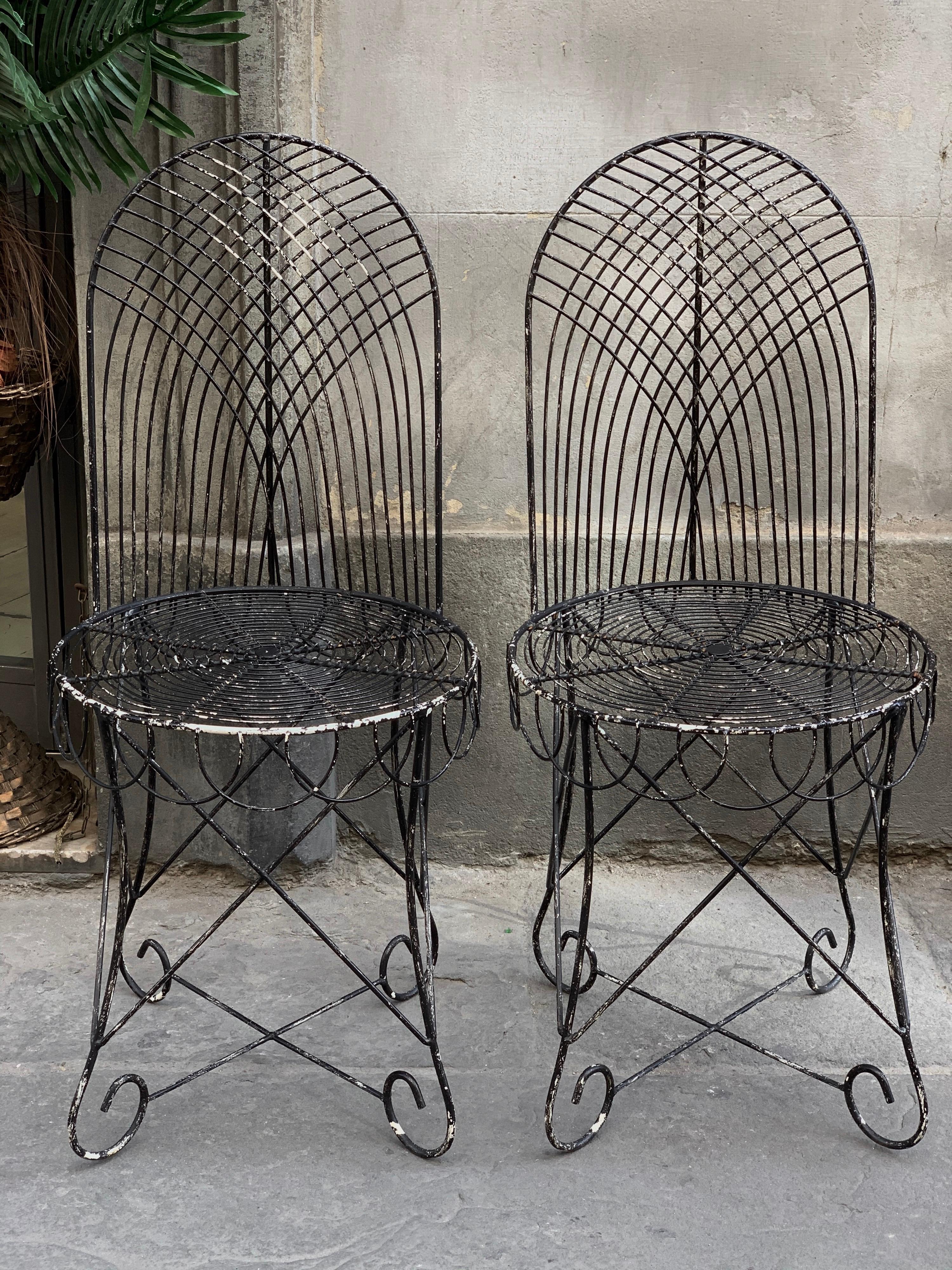 Vintage black wrought iron midcentury garden pair of chairs. The chairs are made of handmade Wrought Iron, the structure has a perfect vintage condition, heavy and stable.
They are painted black, many paint wear that gives the vintage