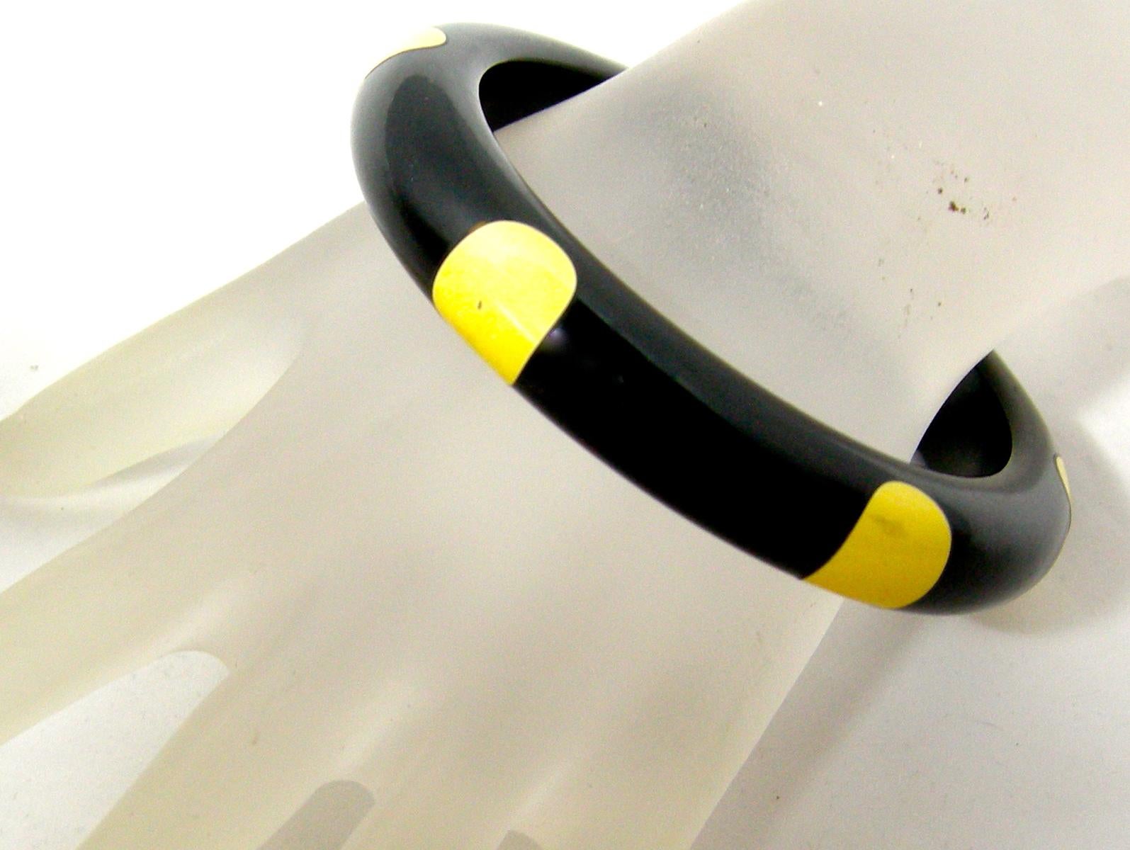This vintage Bakelite bracelet has the famous yellow elongated  “dot” on black Bakelite.  In excellent condition, this bangle measures 8” around the inside x 1/2” wide.