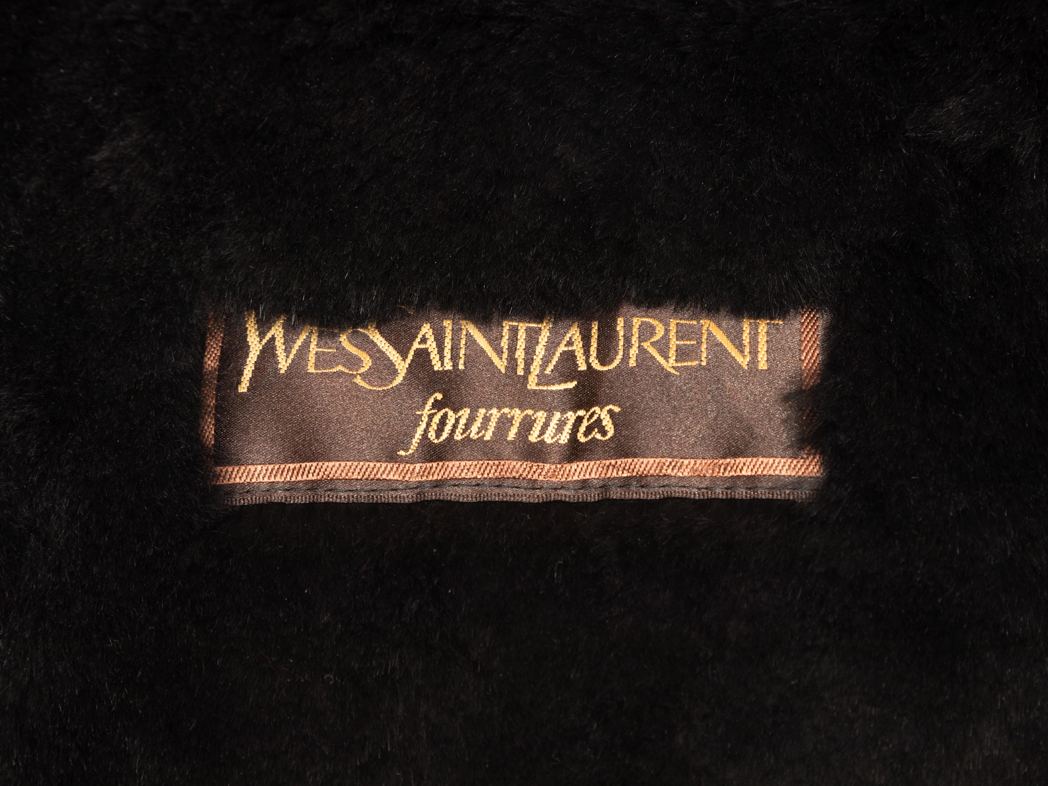 Cappotto vintage in pelle e pelliccia nera di Yves Saint Laurent. Circa anni '80. Decorazione con borchie dorate su tutta la superficie. Doppie tasche sui fianchi. Chiusura frontale. Seno 44