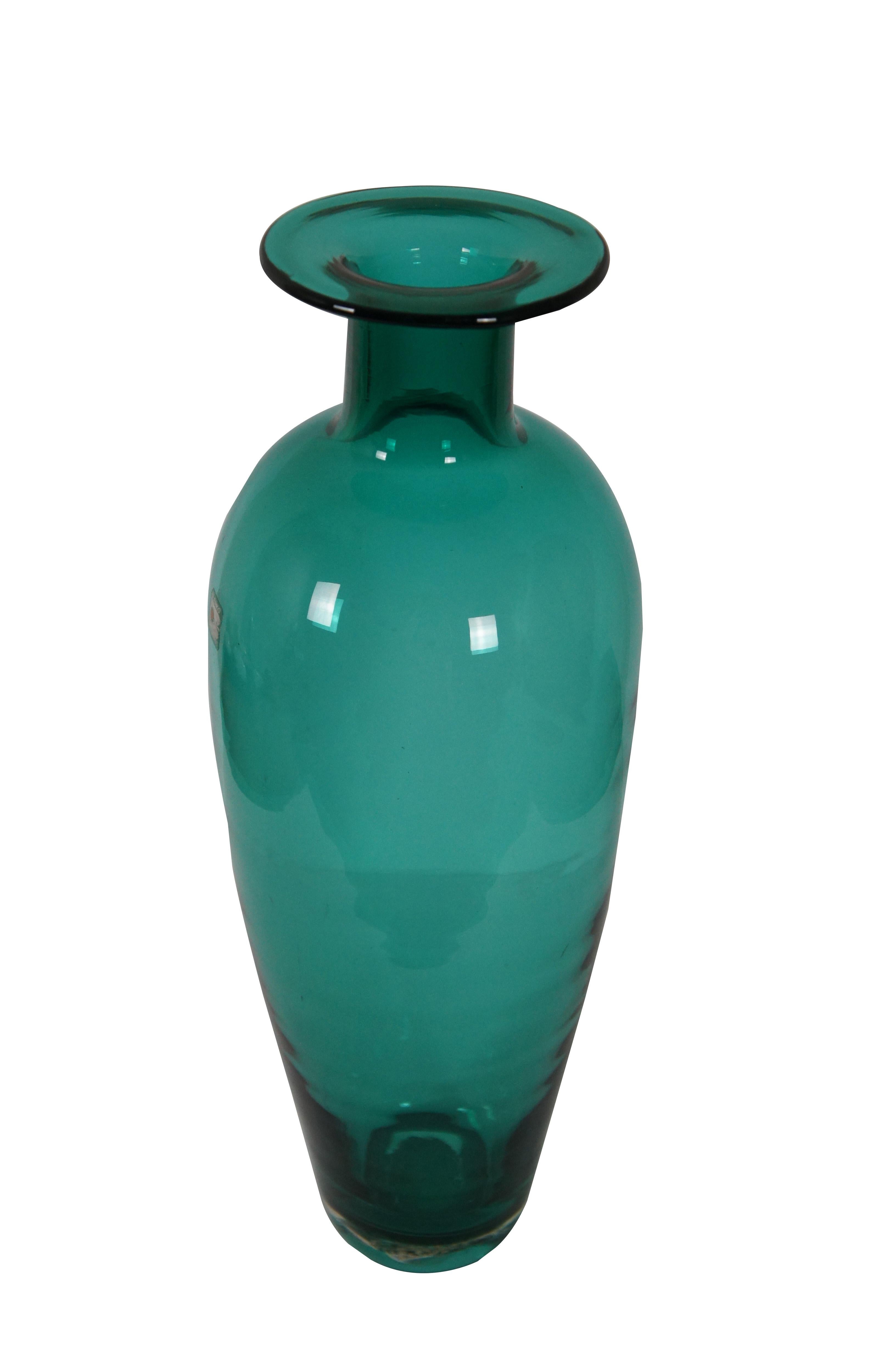Mid century modern (1960s) large Blenko hand blown emerald green / teal glass vase featuring a rounded body with tapered base, narrower neck, and a flat disc shaped rim. Original sticker on side.

Dimensions:
7” x 18.75” (Diameter x Height)