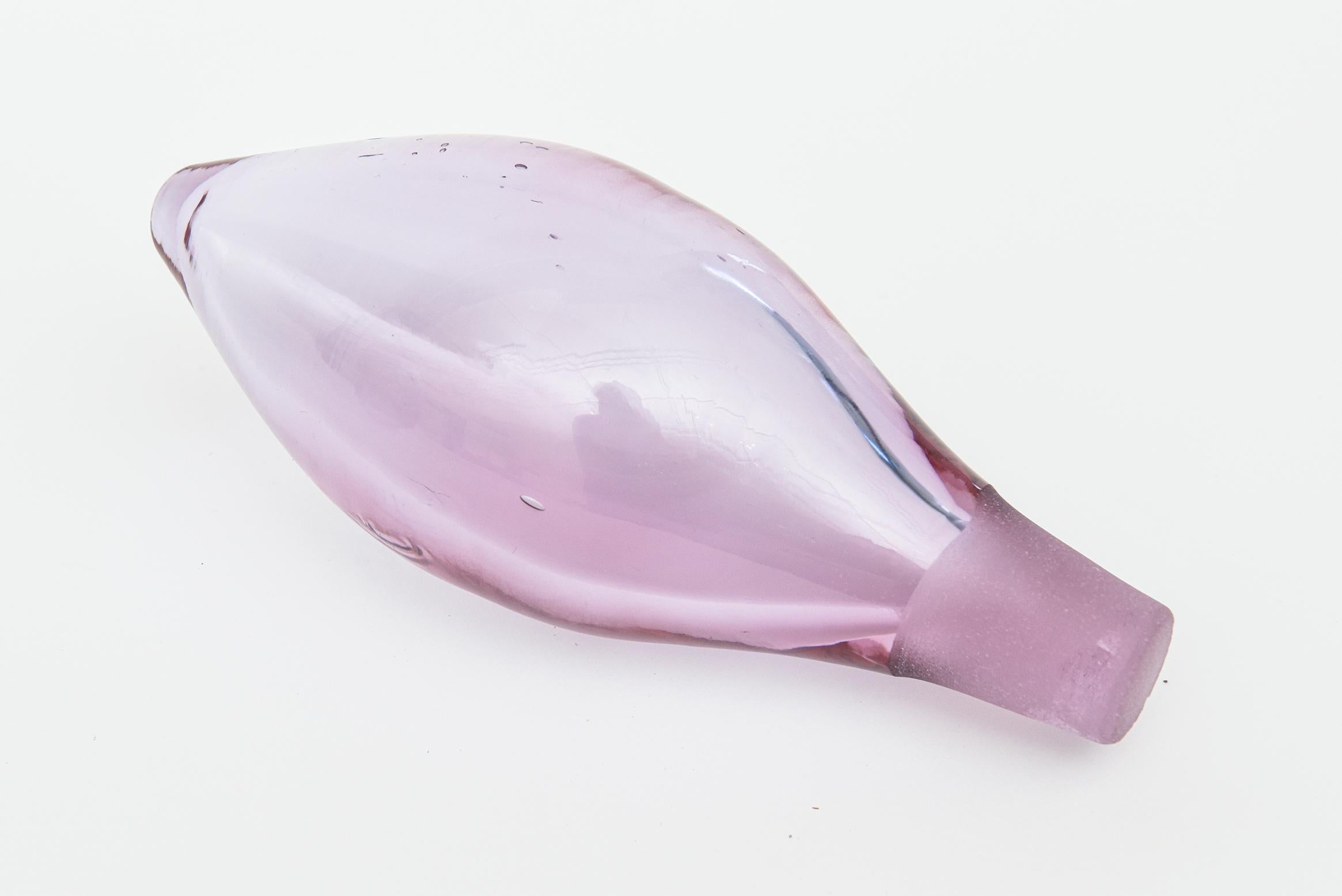 This lovely vintage molded glass decanter bottle by Blenko has a teardrop original long stopper. The design on the front and back are abstract bodies and forms that are raised from the molded glass. It is a light purple of a luscious color wave.