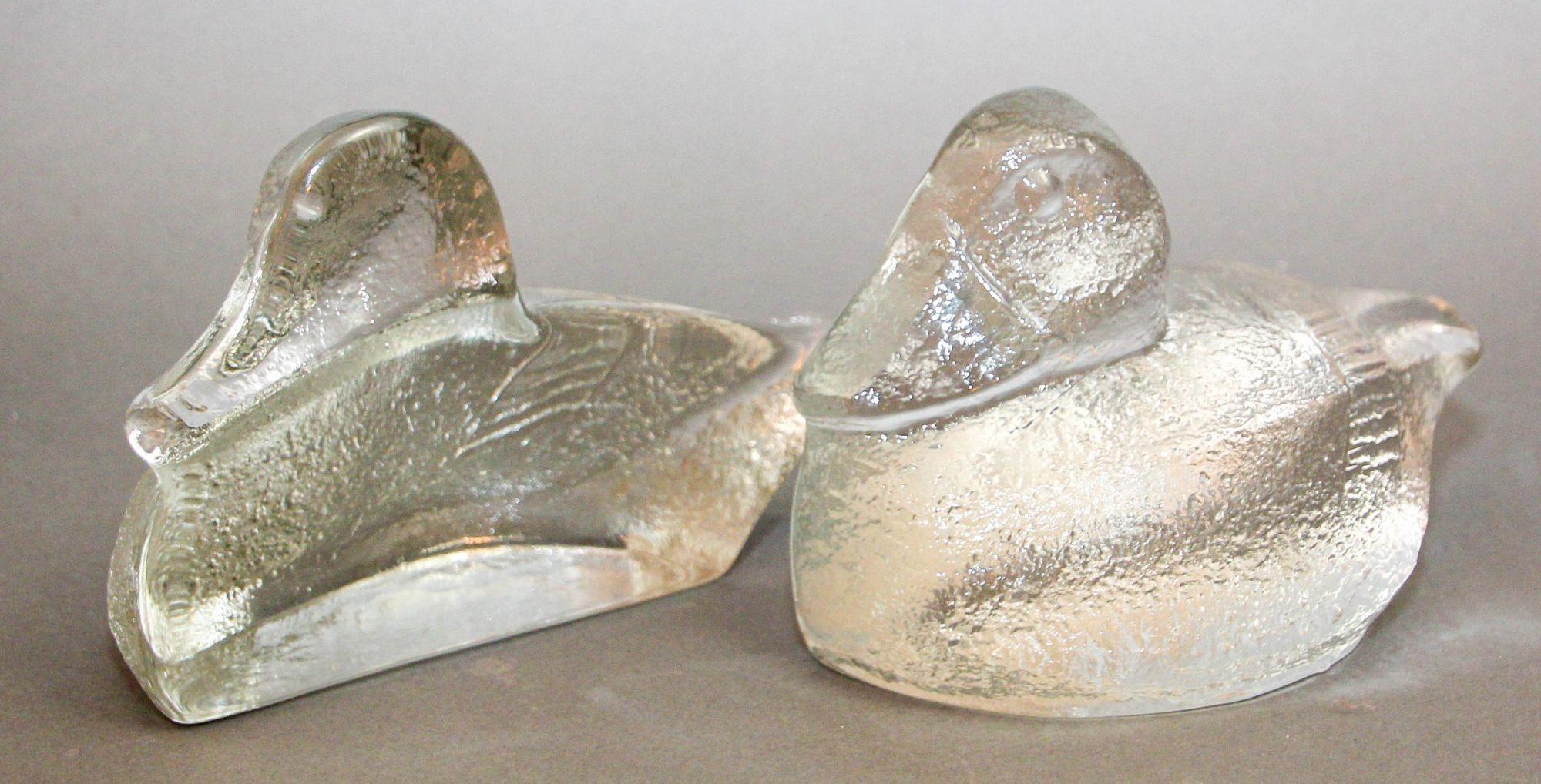 Auffälliges Paar Bücherstützen aus Entenglas von Blenko, ca. 1980er Jahre.
Ein Paar Blenko Ducks Buchstützen aus klarem, strukturiertem Glas.
Ein Paar handgefertigte, schwere und robuste Buchstützen aus Glas mit strukturierten Seiten von Blenko