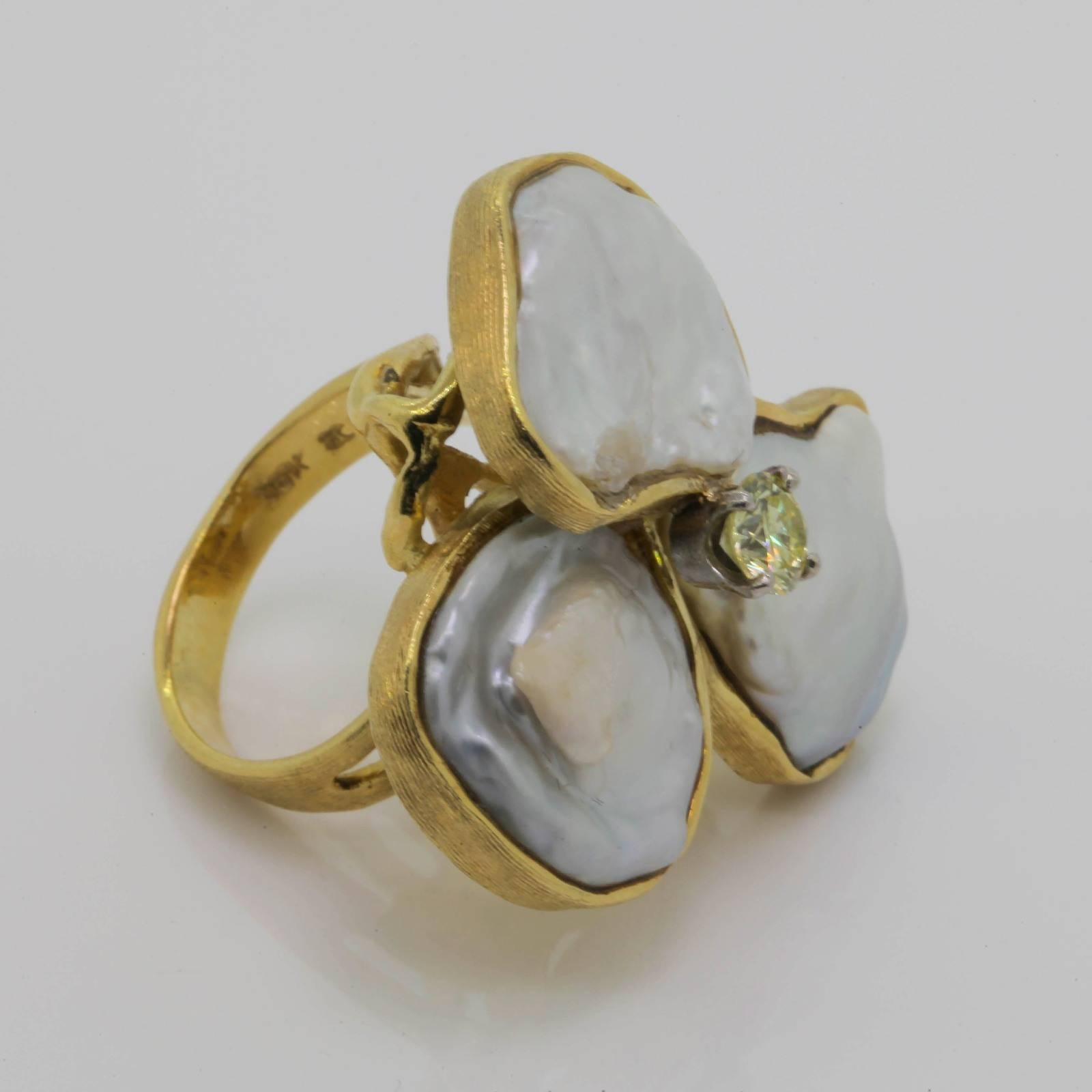 Delightfully attractive 1970s 18KT gold ring.  The blooming flower design ring flaunts three irregular Blister Pearls and in the center a natural Yellow color Round Brilliant Cut Diamond.  The diamond weighs 0.50 carat of VS clarity.  The Pearls are