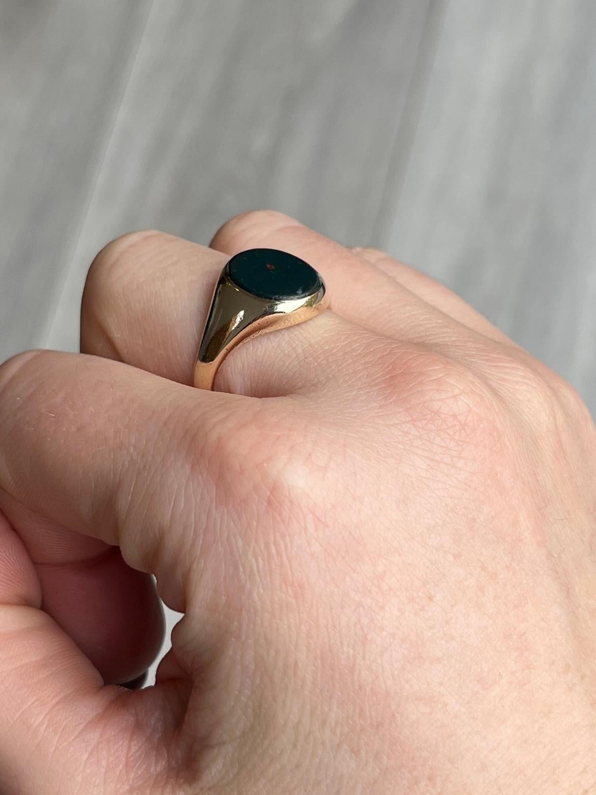 This gorgeous signet ring has a bloodstone set flush within the 9carat gold band. The stone is deep green with flecks of red running through. Hallmarked London 1956. 

Ring Size: R 1/2 or 8 3/4 
Stone dimensions: 10x12mm 

Weight: 5.5g 