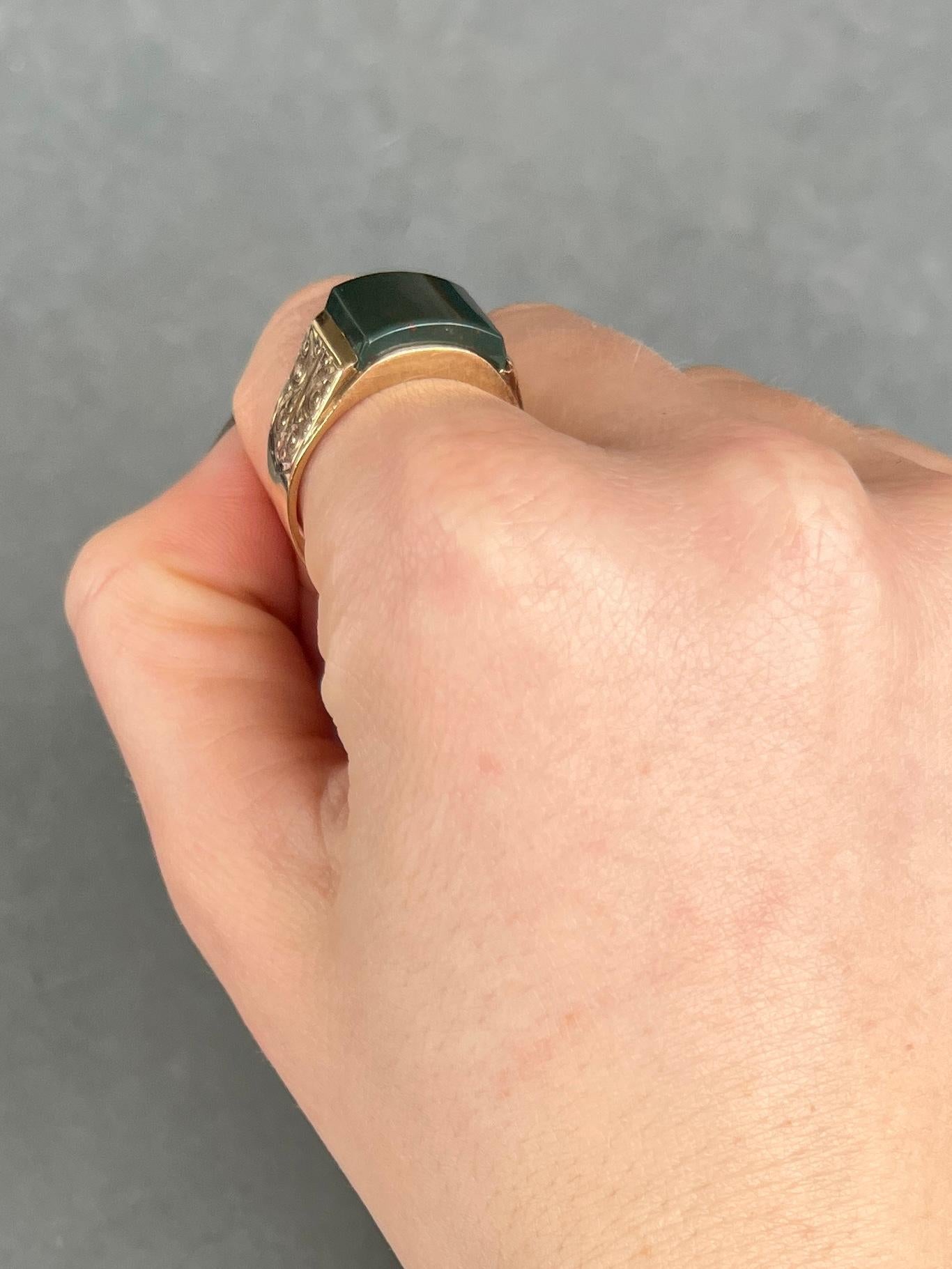 This gorgeous signet ring has a curved bloodstone set flush within the 9carat gold band. The stone is deep green with flecks of red running through and the shoulders of the ring have engraved detail. Hallmarked London 1975.

Ring Size: T 1/2 or 9