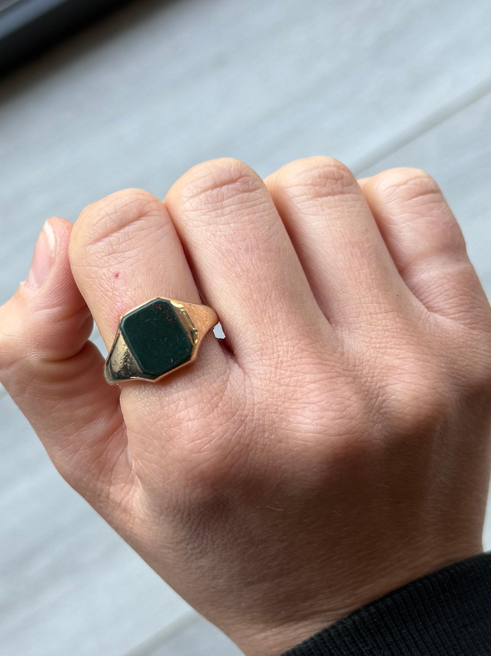Questo splendido anello con sigillo ha una pietra di sangue incastonata nella fascia d'oro da 9 carati. La pietra è di colore verde intenso con macchie di rosso. Completamente marcato Birmingham 1964.

Misura dell'anello: T 1/2 o 9 3/4
Dimensioni