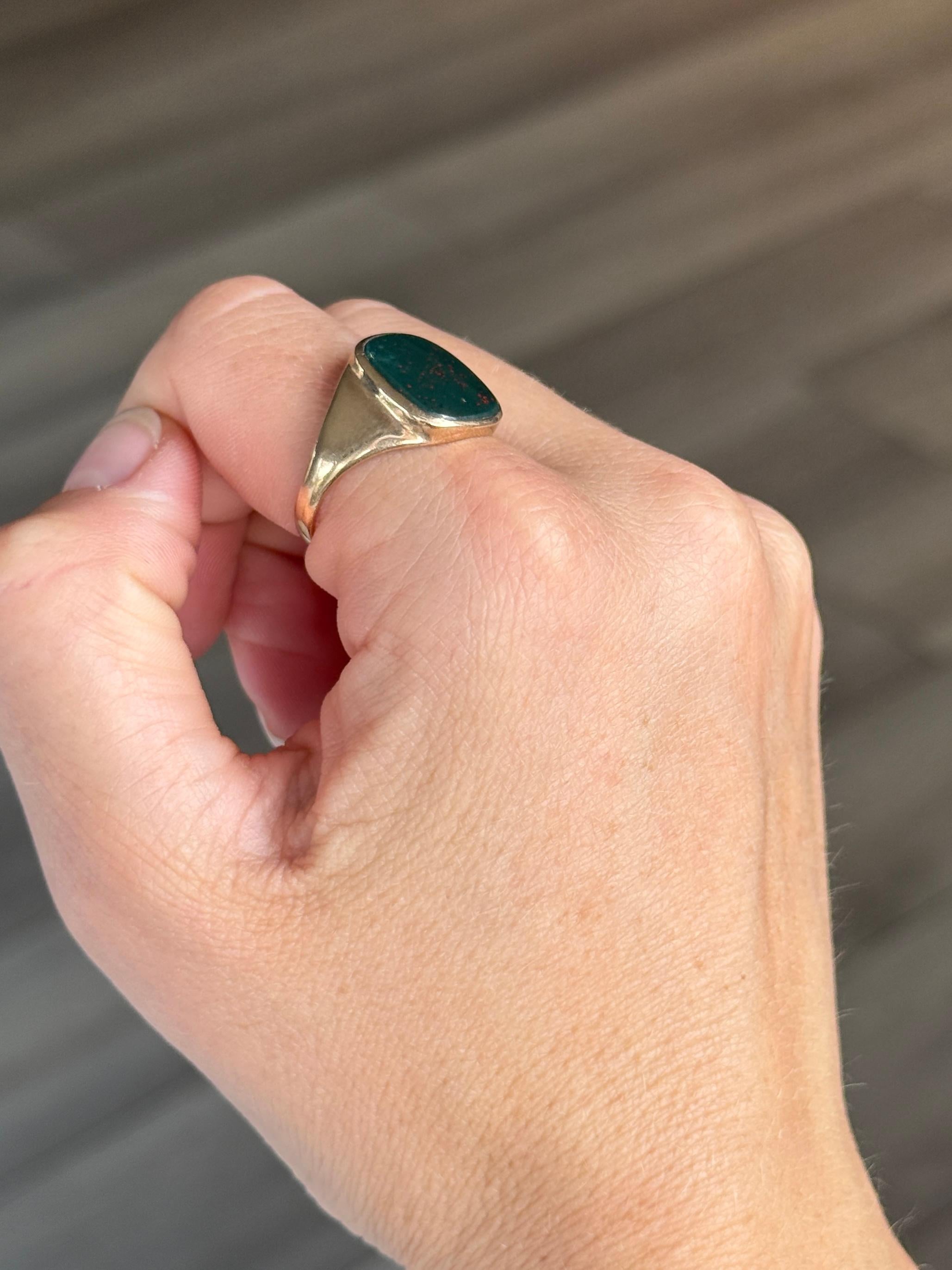 Cette magnifique chevalière est ornée d'une pierre de sang sertie dans un anneau d'or 9 carats. La pierre est d'un vert profond traversé de taches rouges. Poinçon de Birmingham 1970.

Taille de la bague : S 1/2 ou 9 1/4
Dimensions de la pierre :