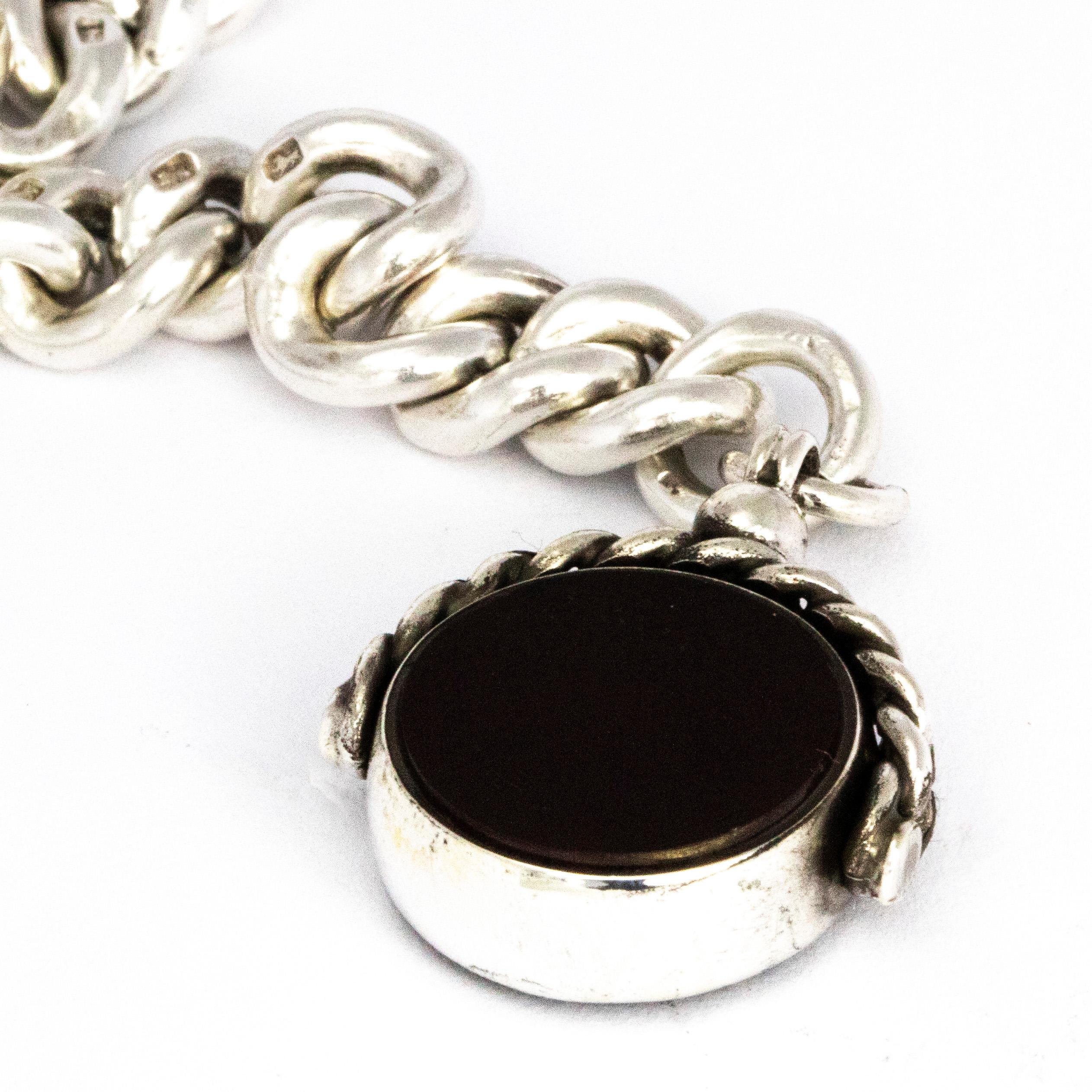 This chunky glossy silver chain holds a swivel fob that has a bloodstone and carnelian set into it and is held with a chain detailed loop. The whole design of this double Albert is chunky and looks so stylish. The chain also features a t bar and a