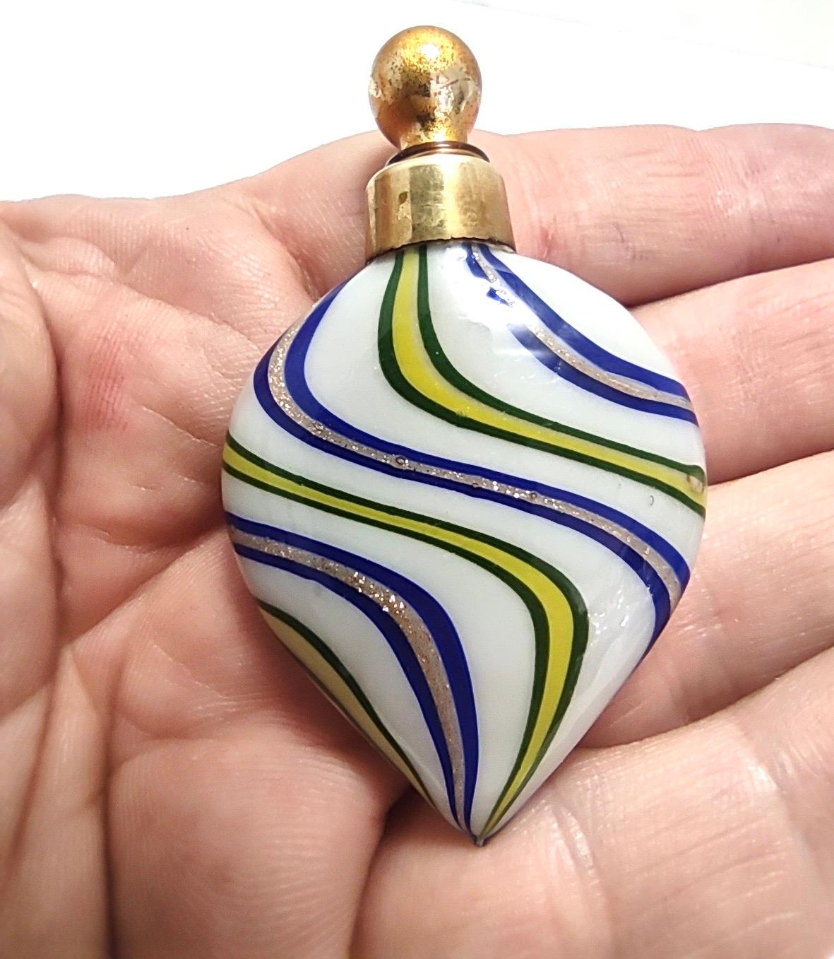 1930s.
This miniature perfume bottle is made in blown-glass canes and brass.
It might show slight traces of use since it's vintage, but it can be considered as in excellent original condition.

Measures: 
Width 4 cm
Depth: 1 
Height: 6.5 cm.

Order