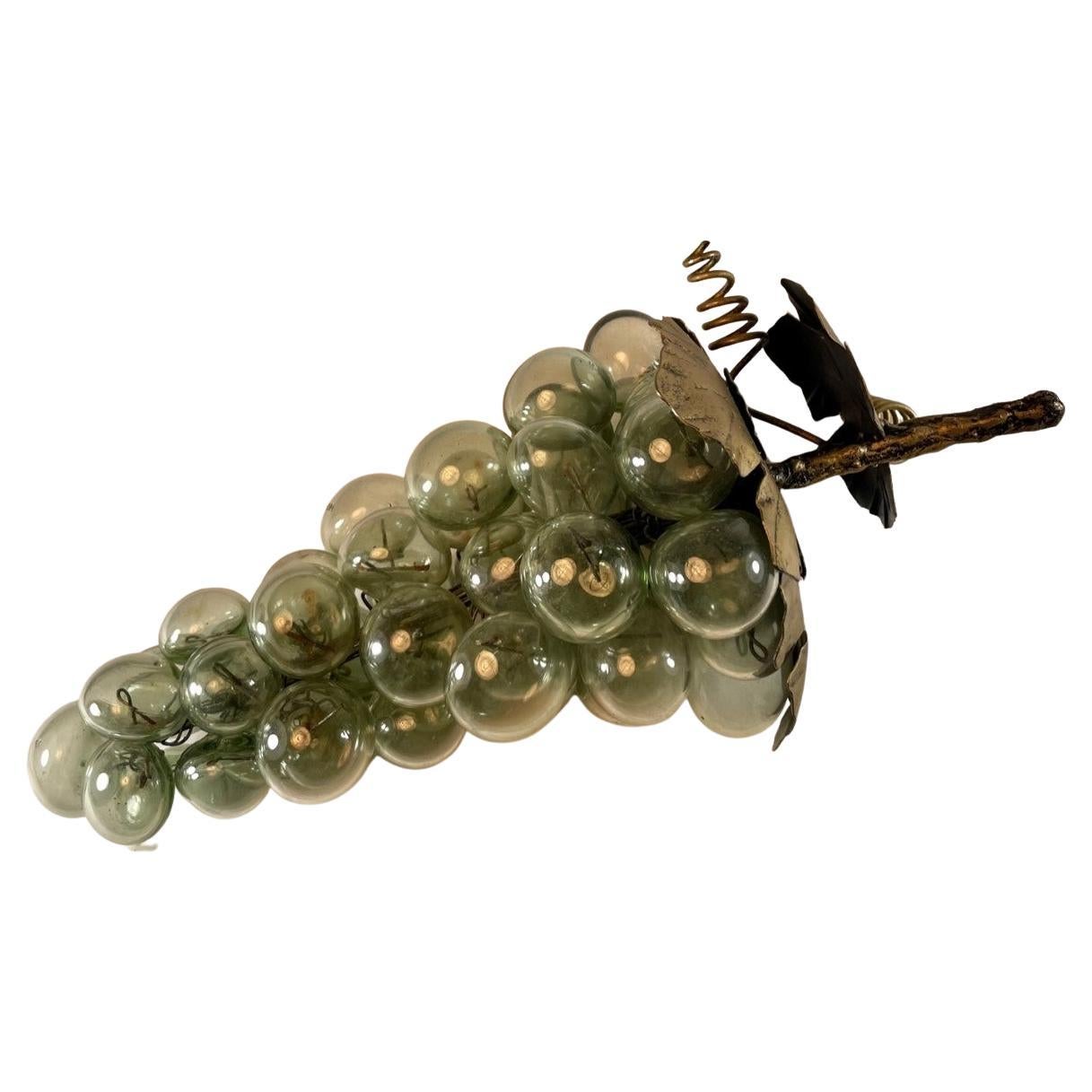 Vintage blown smokey glass grapes sculpture.

Large and beautiful blown glass grape cluster. A bronzed metal stem with metal leaves and vines connects the smokey glass grapes through the sculpture. The clustered grapes are wired from the stem into