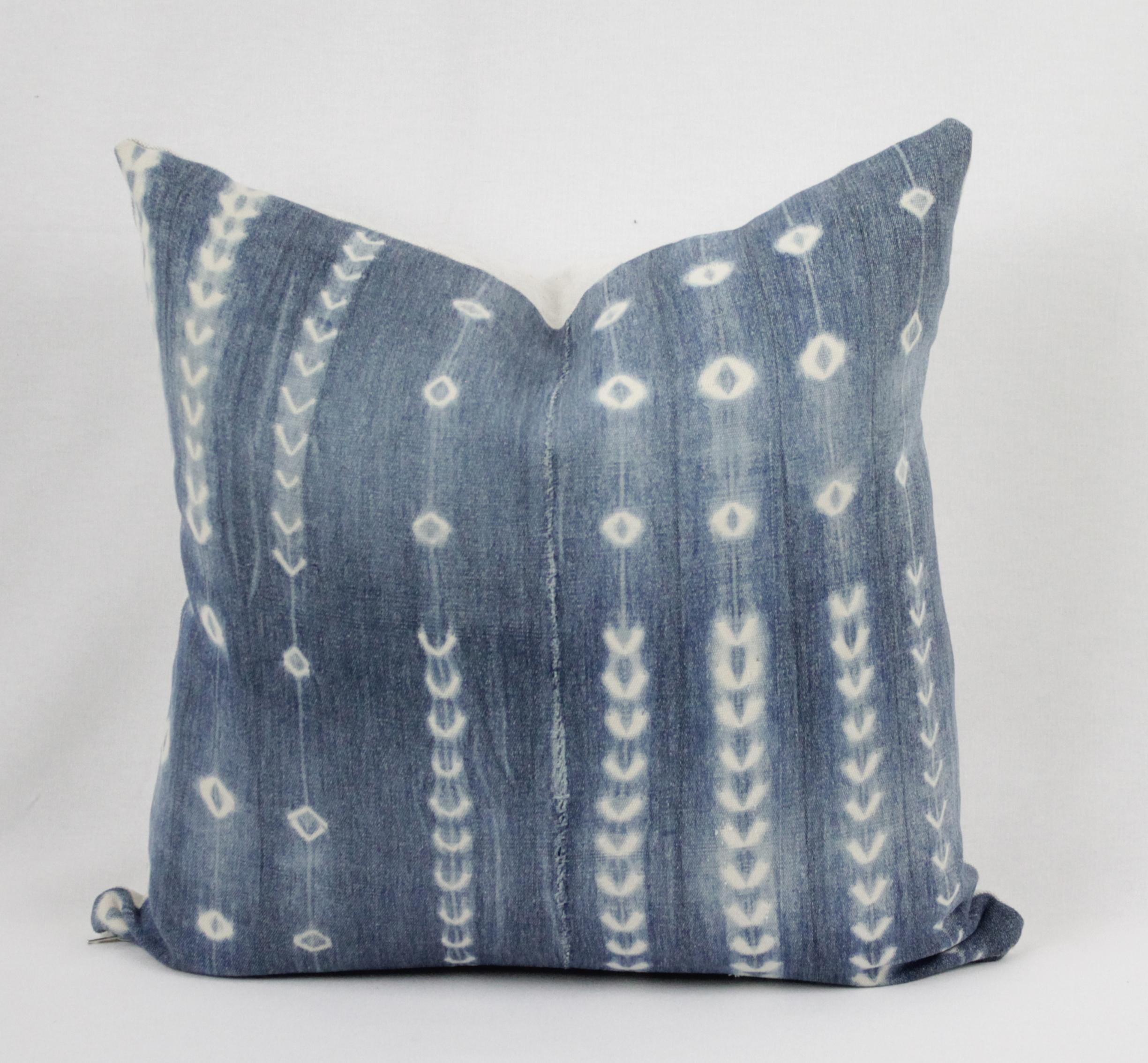 Vintage blue and white batik style pillow, with zipper closure. Pillow has vertical exposed seams and front is lined in white linen. Back is in a natural color linen and finished with overlocked edges. Main color is a medium shade of blue and off
