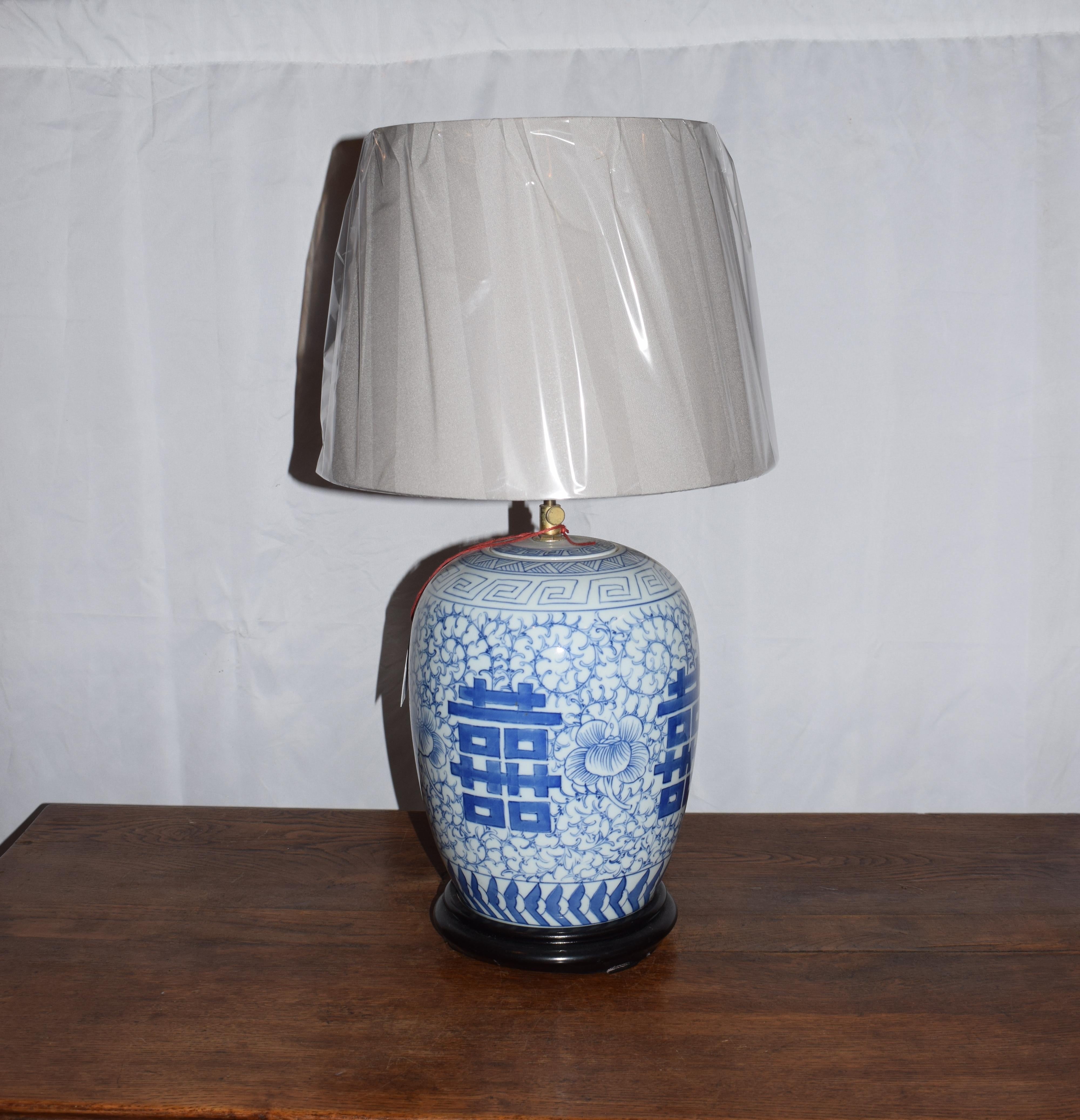 Lampe de table en céramique chinoise de type pot à gingembre. Cette jarre est décorée des quatre symboles chinois de double chance. Elle est émaillée dans des couleurs bleu cobalt et blanc ivoire. La base est en bois de rose. Il est originaire