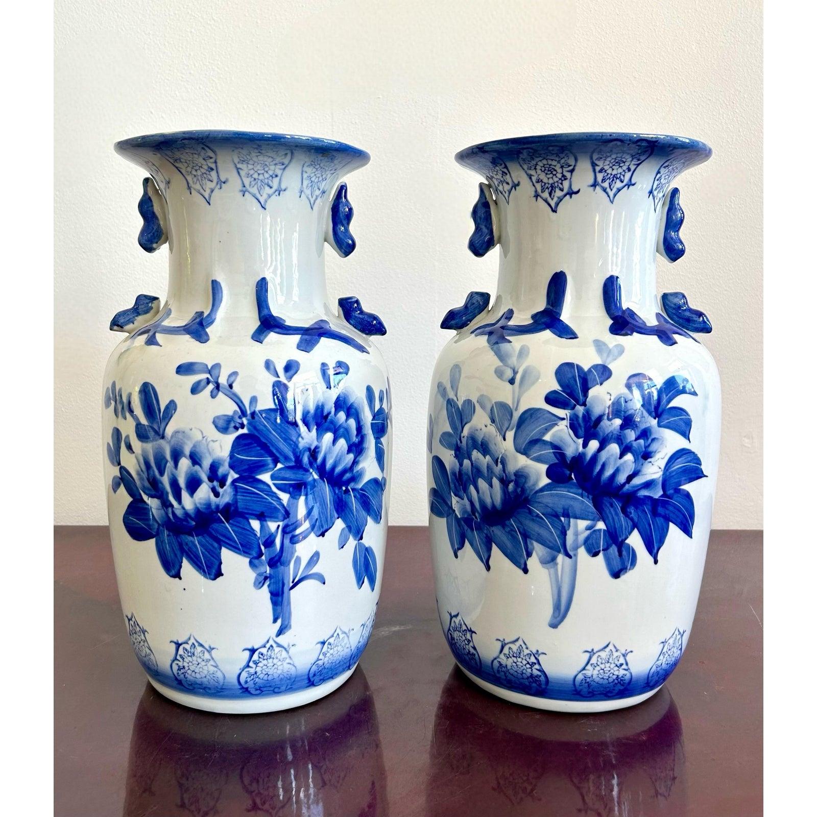 Questa sorprendente coppia di vasi in porcellana bianca e blu mostra un'arte senza tempo di ispirazione cinese con una freschezza moderna.Audaci motivi floreali sbocciano sulla superficie bianca liscia, resi in profondi toni cobalto che sembrano
