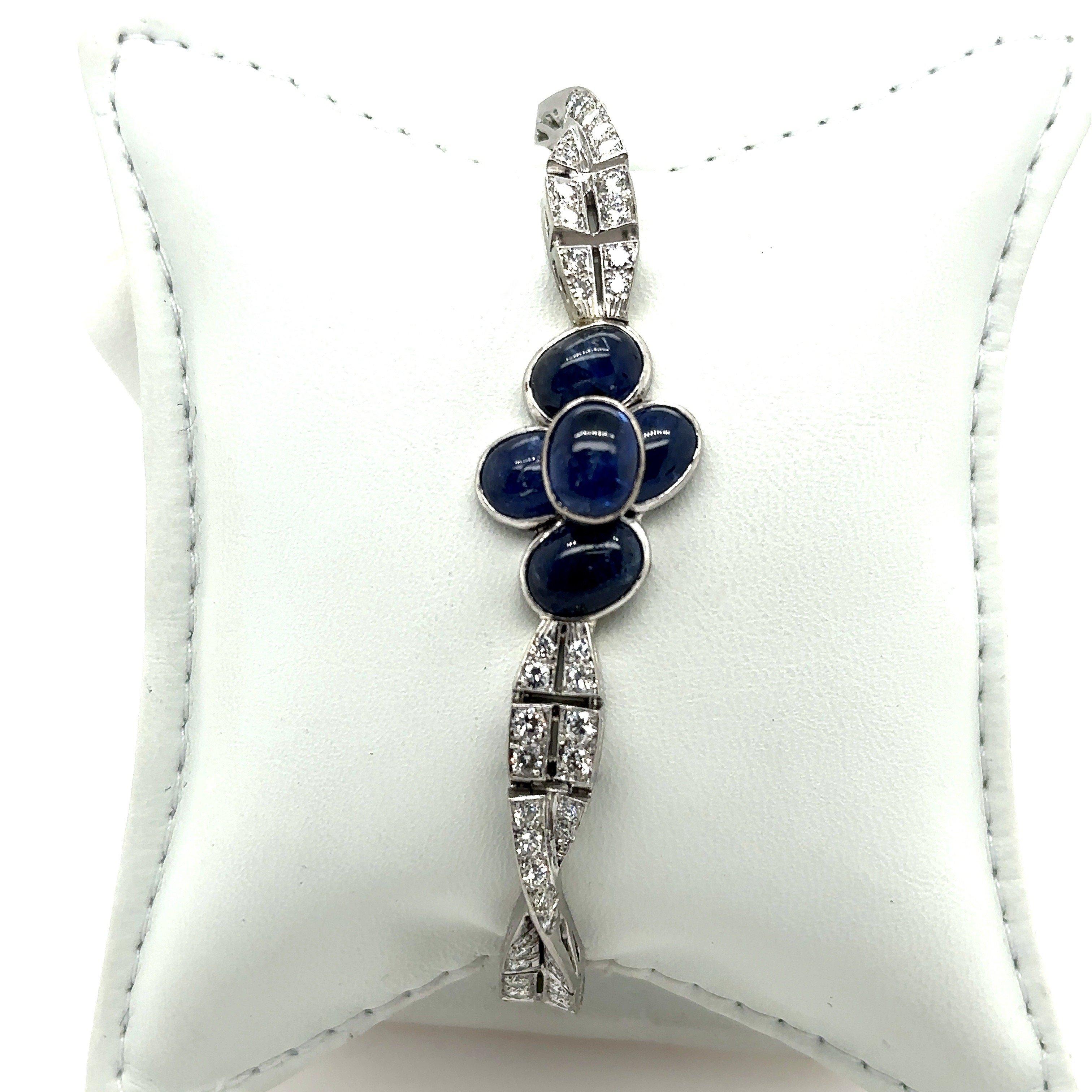 This vintage bracelet dates from the 1950’s. It’s crafted in platinum and features five bezel-set oval blue cabochon sapphires at the center that weight approximately 5.10 carats. The center of the bracelet measures approximately  15.7mm at the
