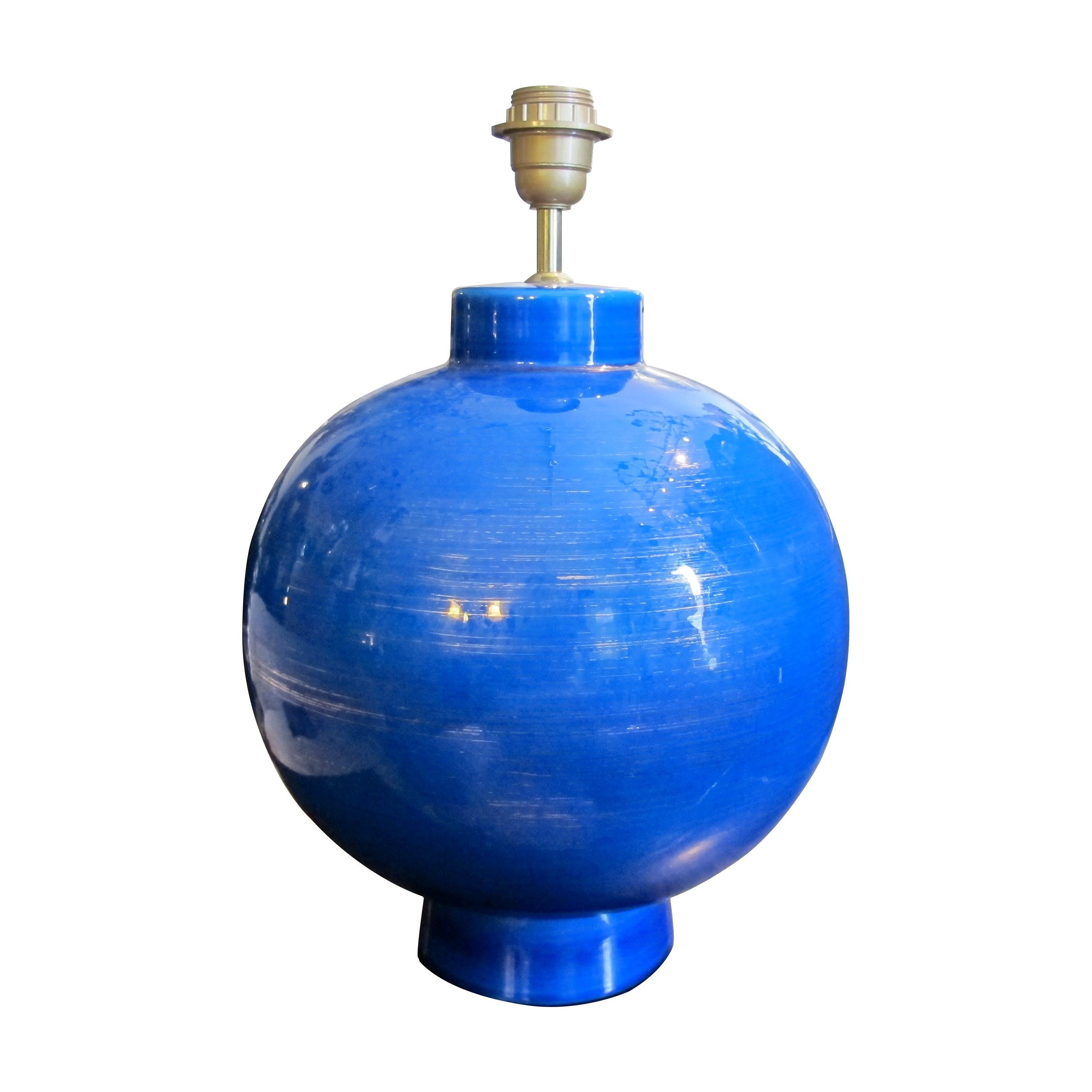 Striking blue ceramic lamp from the 1970s, signed by L. Drummer. The lamp features a bold, spherical base with a rich, glossy glaze in a deep cobalt blue, highlighted by subtle tonal variations that add depth and character to the surface.

Size: H45