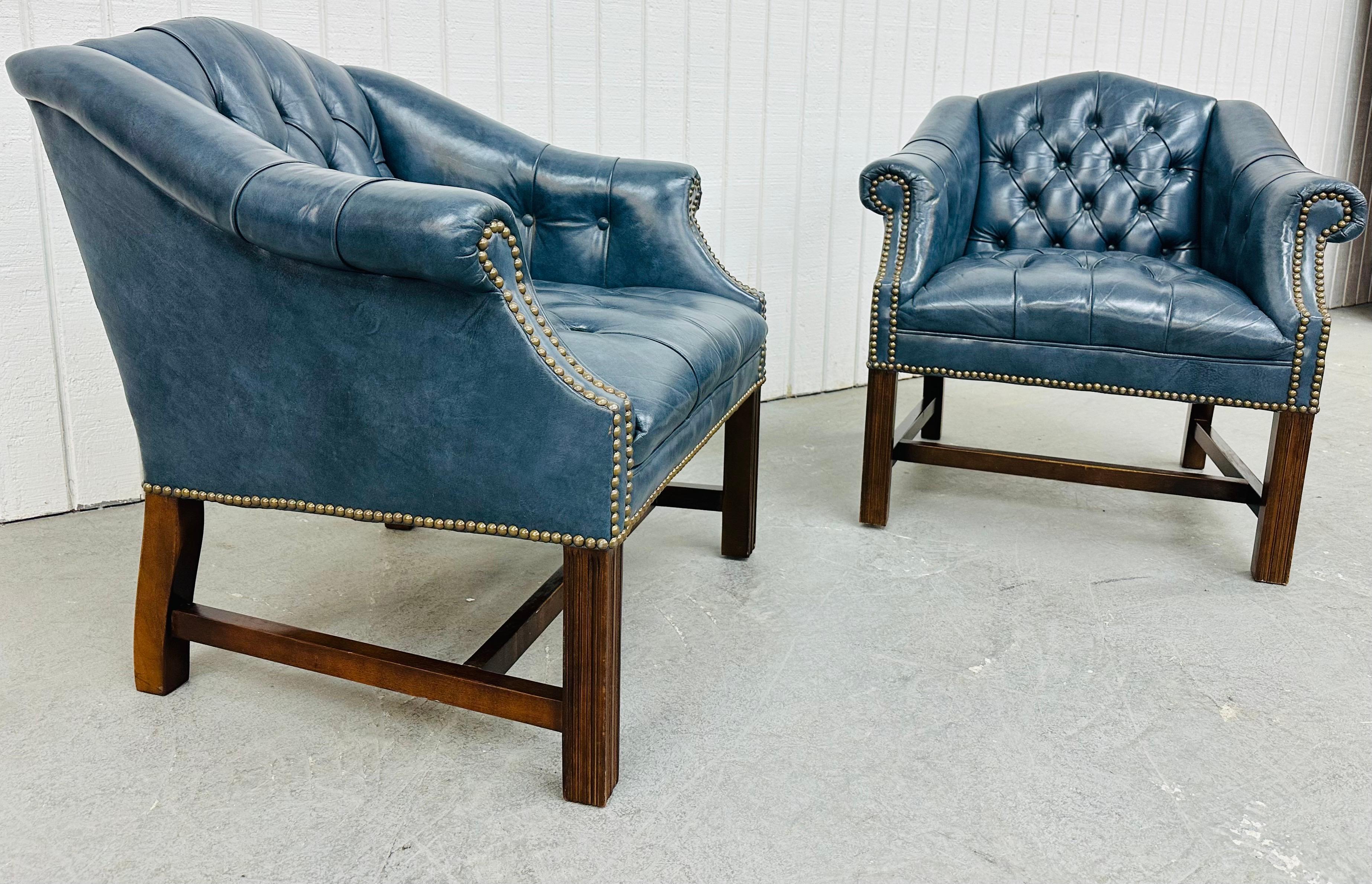 This listing is for a pair of Vintage Blue Chesterfield Arm Chairs. Featuring a chesterfield style design, nailhead trim, mahogany legs, and a beautiful blue leather upholstery. This is an exceptional combination of quality and design!
