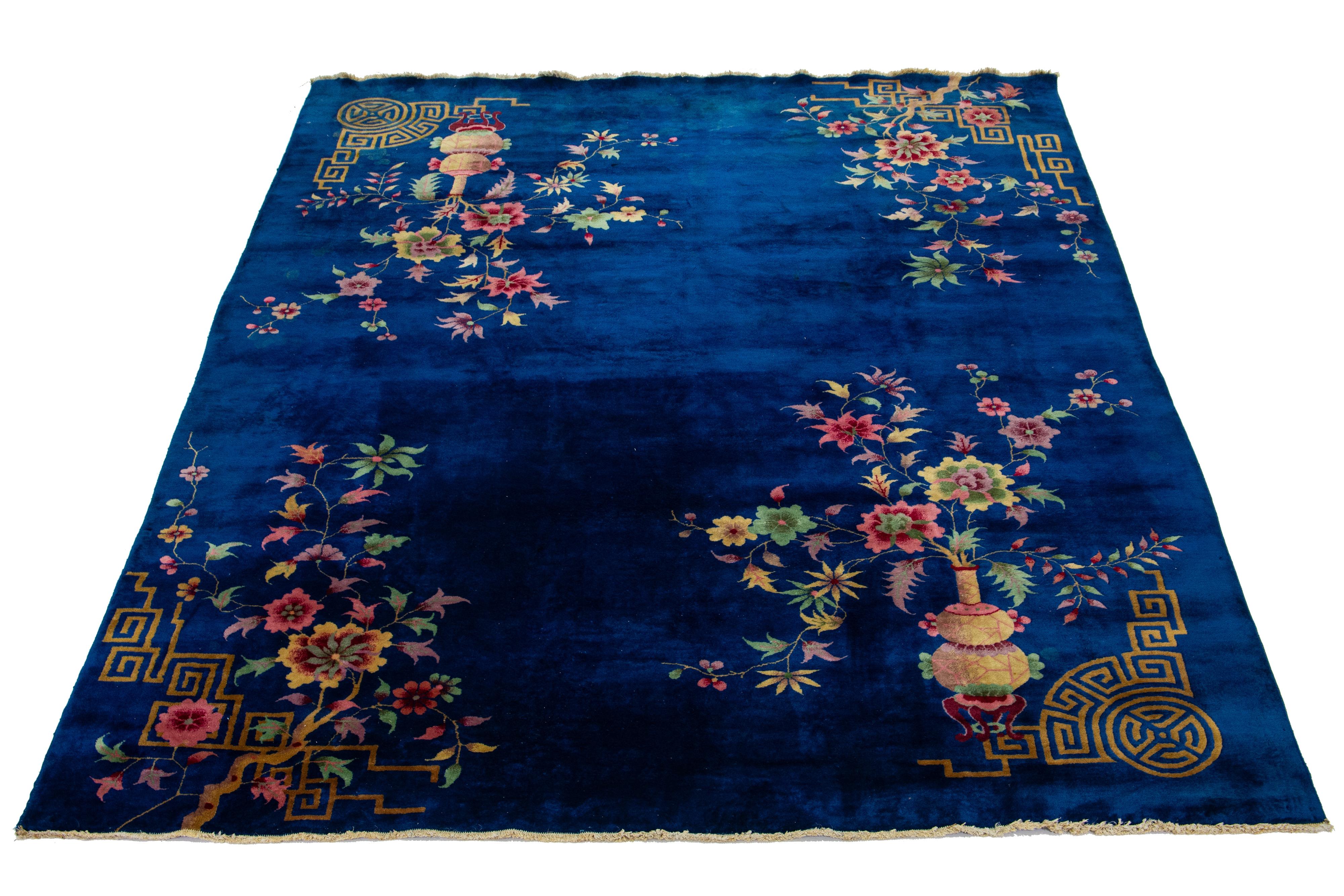 A stunning antique Chinese Art Deco wool rug with a blue backdrop and various multicolored accents featuring a charming all-over floral design. This exceptional rug dates back to circa 1920.

This rug measures 8' 5