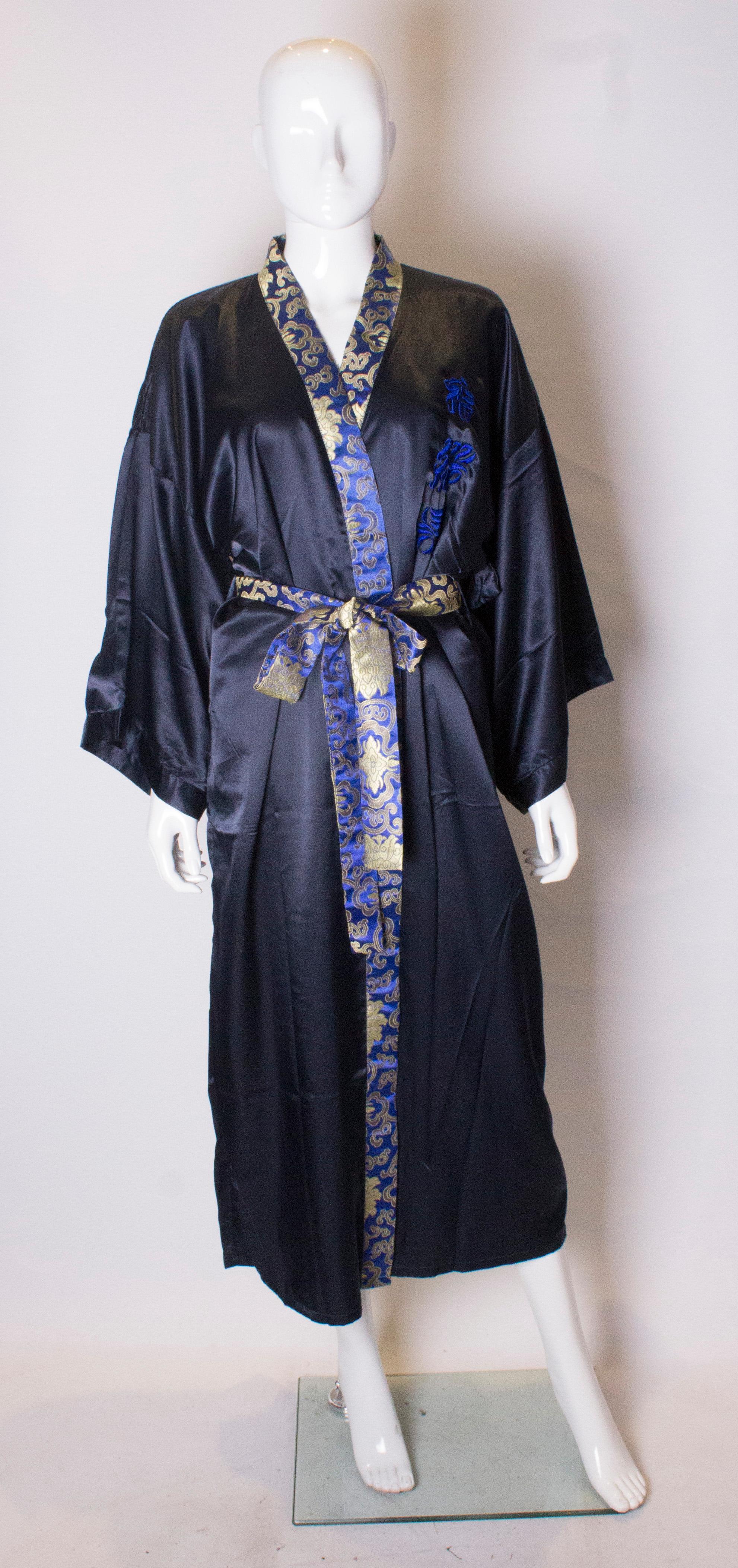A beautiful blue silk vintage dressing gown. The gown is a wonderful shade of blue with wonderful peacock embroidery on the back. It is fully lined, trimmed in printed silk and has a belt in the same fabric and embroidered letters on the front.