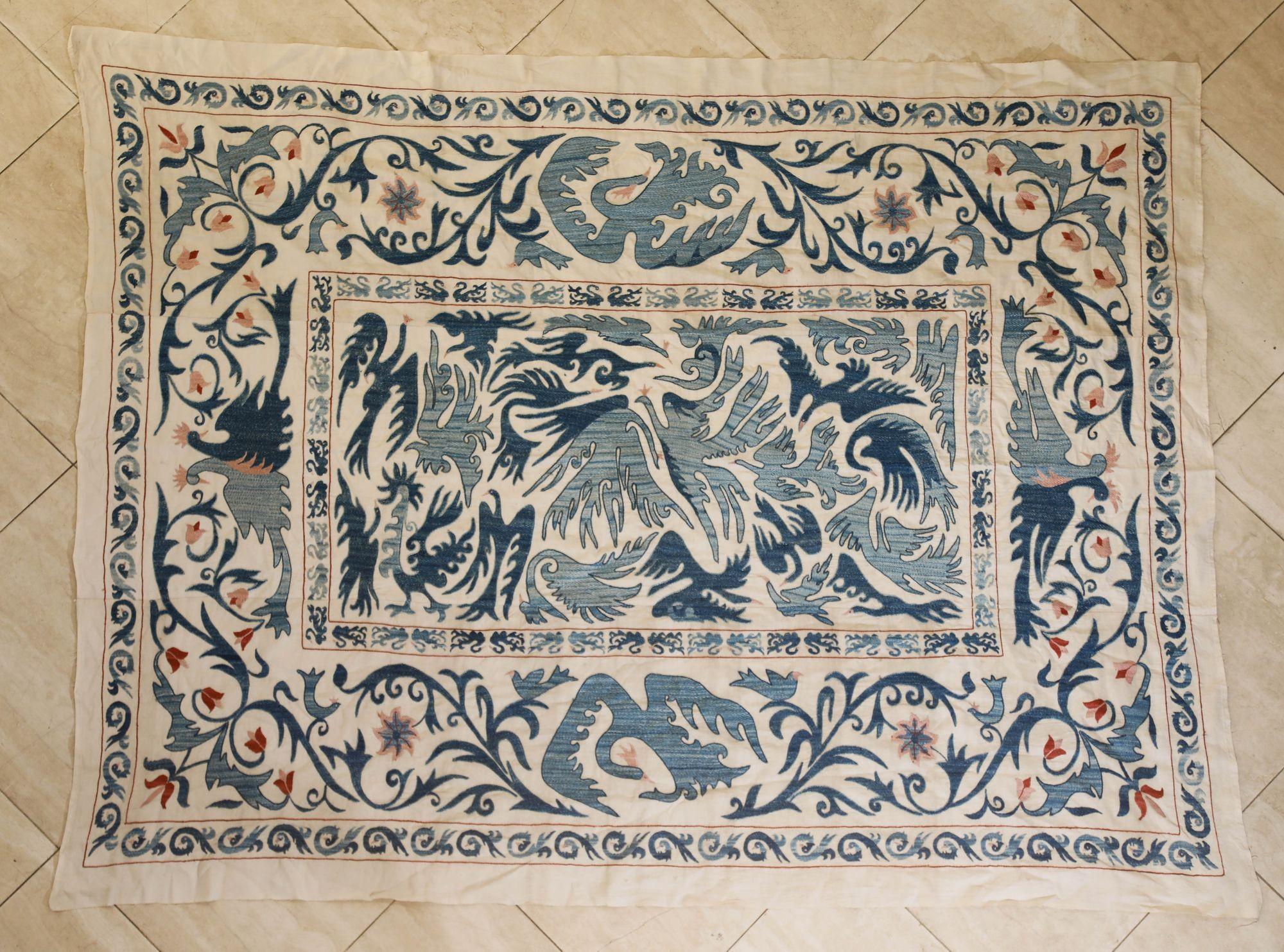 Rare and beautiful silk hand-embroidered suzani from Uzbekistan in stunning multi-colours in light blue and some red accent on a white background.
Made from multiple pieces sewn together.
With multiple blue embroidered botanical, floral and birds