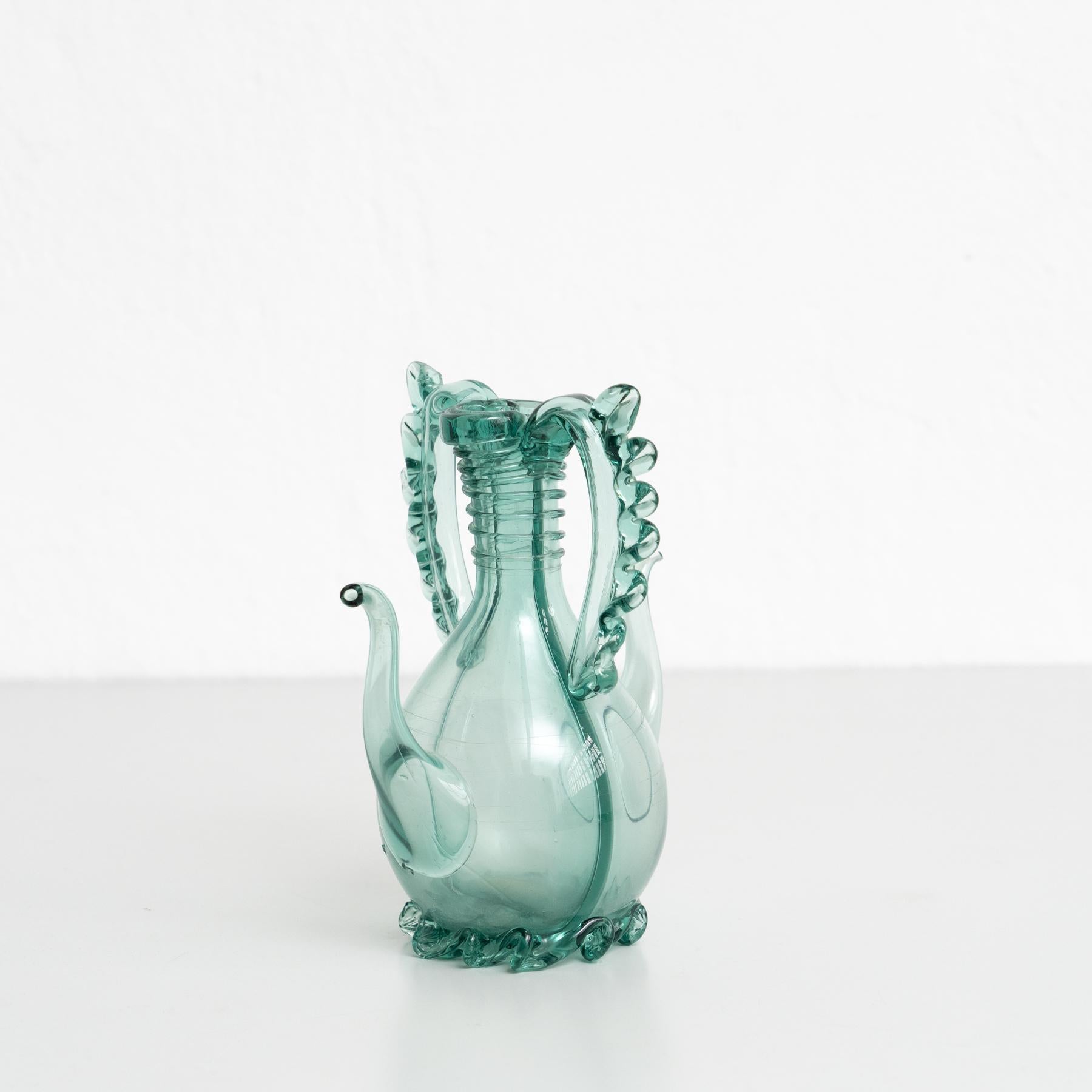 Immerse yourself in nostalgia with this beautiful blue - green blown glass oil cruet dating back to around 1940. This charming piece is a testament to mid-20th-century craftsmanship, evoking the warmth of a bygone era.

The subtlety of the amber