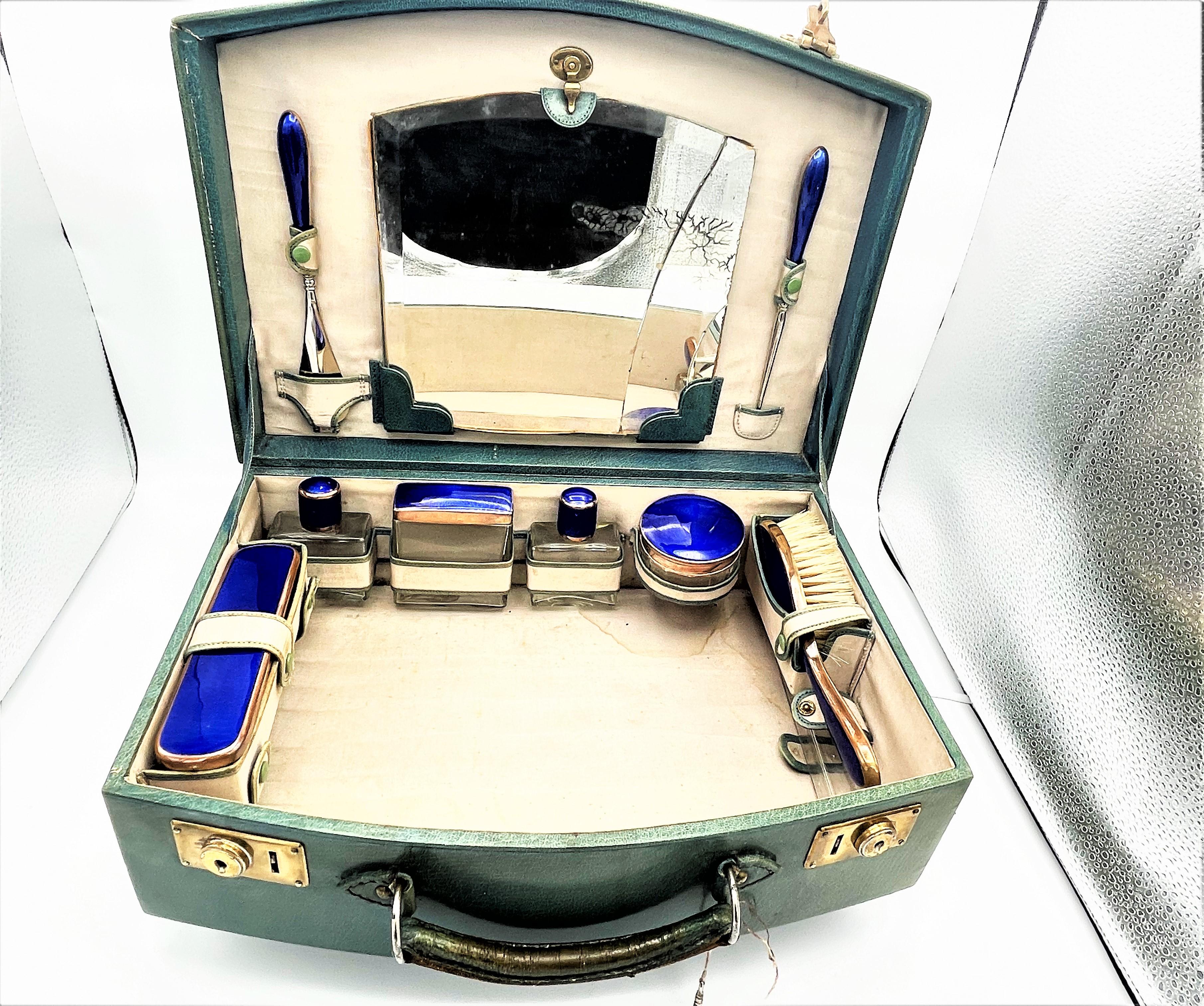 A small original beauty case with many (5) original glass containers, all with blue emailed lids. Also a clothes brush, hairbrush, shoehorn, 2 perfume bottles with a glass stopper, as well as a glass container for the toothbrush .All parts in