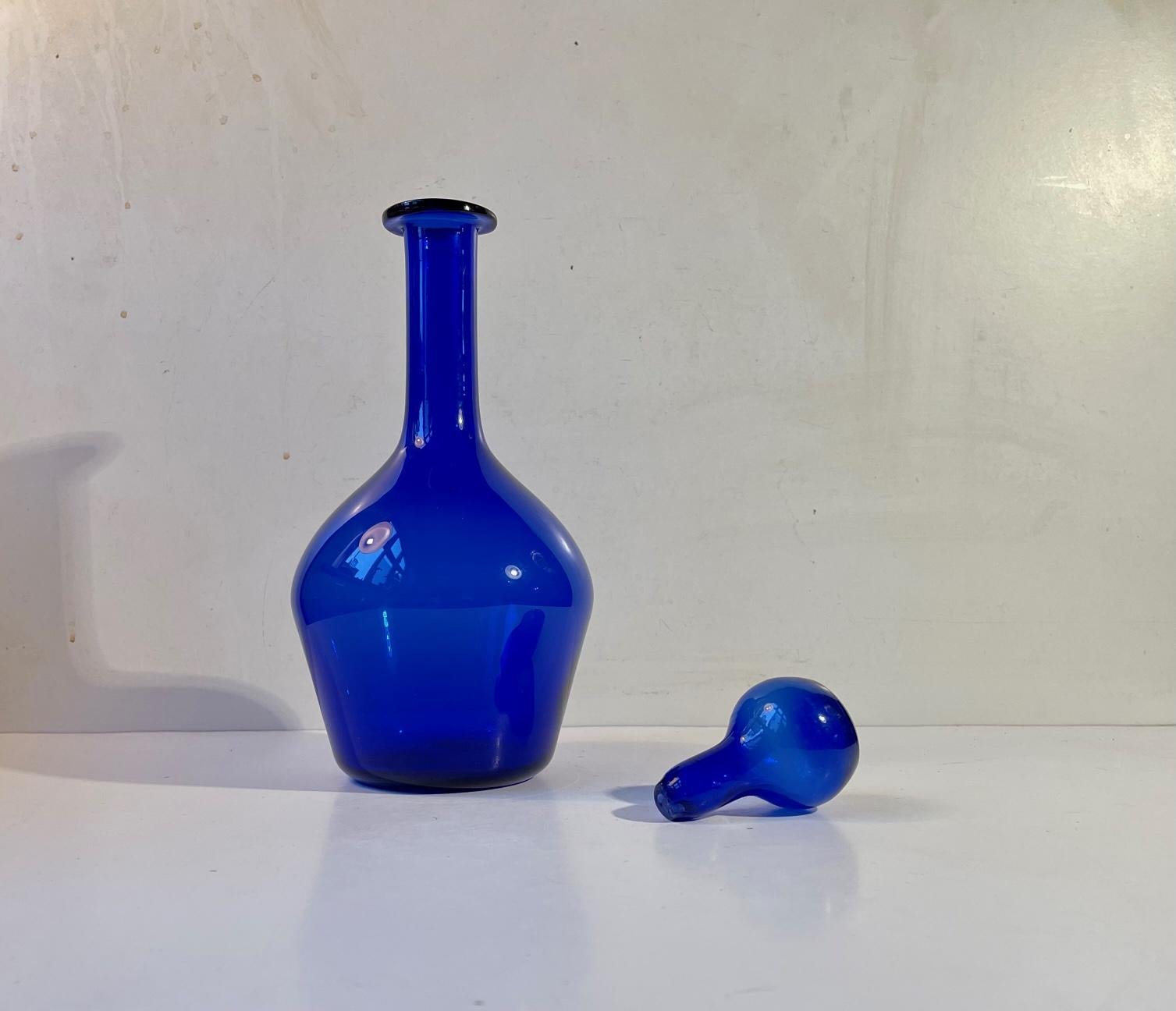Hand-blown cobalt blue glass decanter with round stopper from Oggretti Murano in Italy. Made during the 1970s or 80s. Measurements: H: 29 cm, D: 13 cm. Capacity: 0.7 liter.