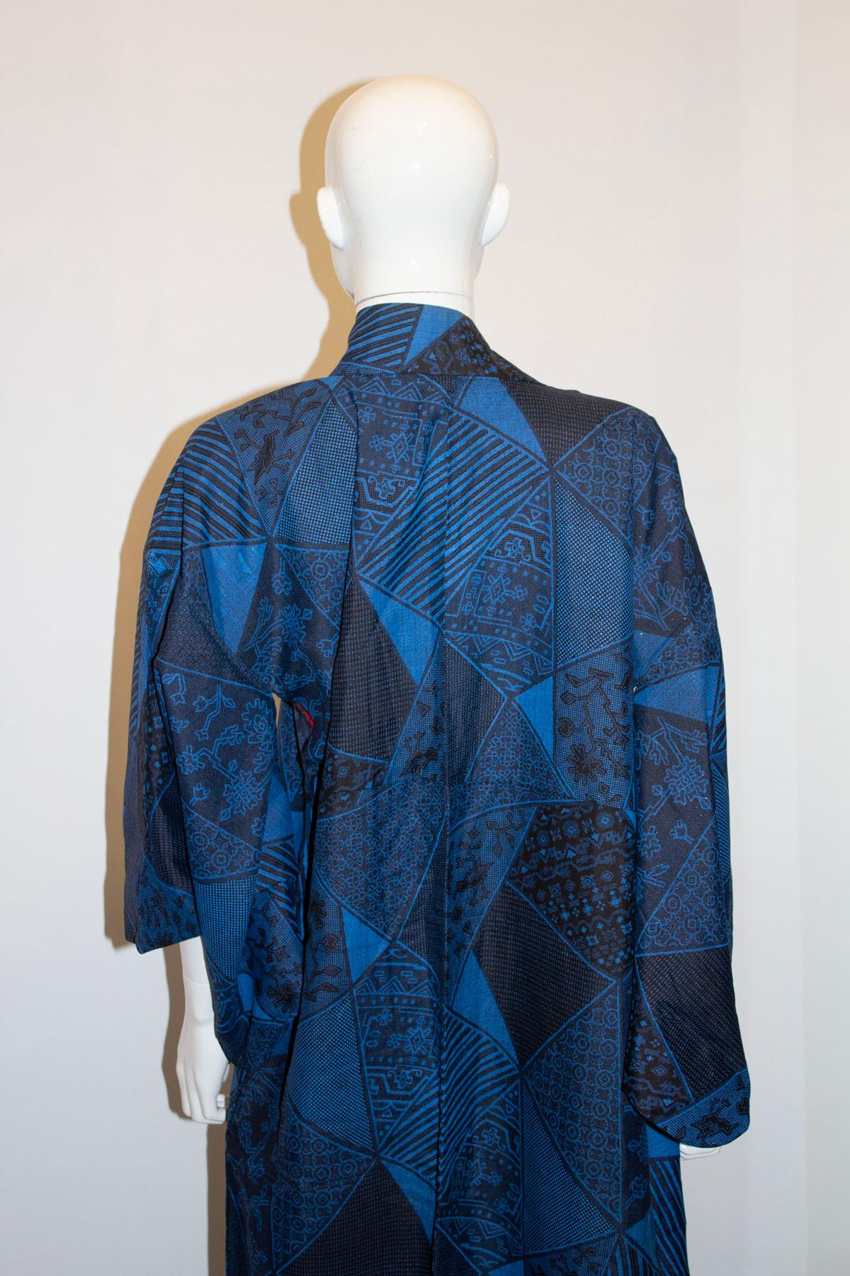 An unusual and interesting vintage kimono. 
The kimono is in a midnight blue colour, with a blue and black print with a slight sparkle detail. The kimono is made of a cotton like fabric and has a red and pink lining. 
Measurements: Bust up to 48'' ,