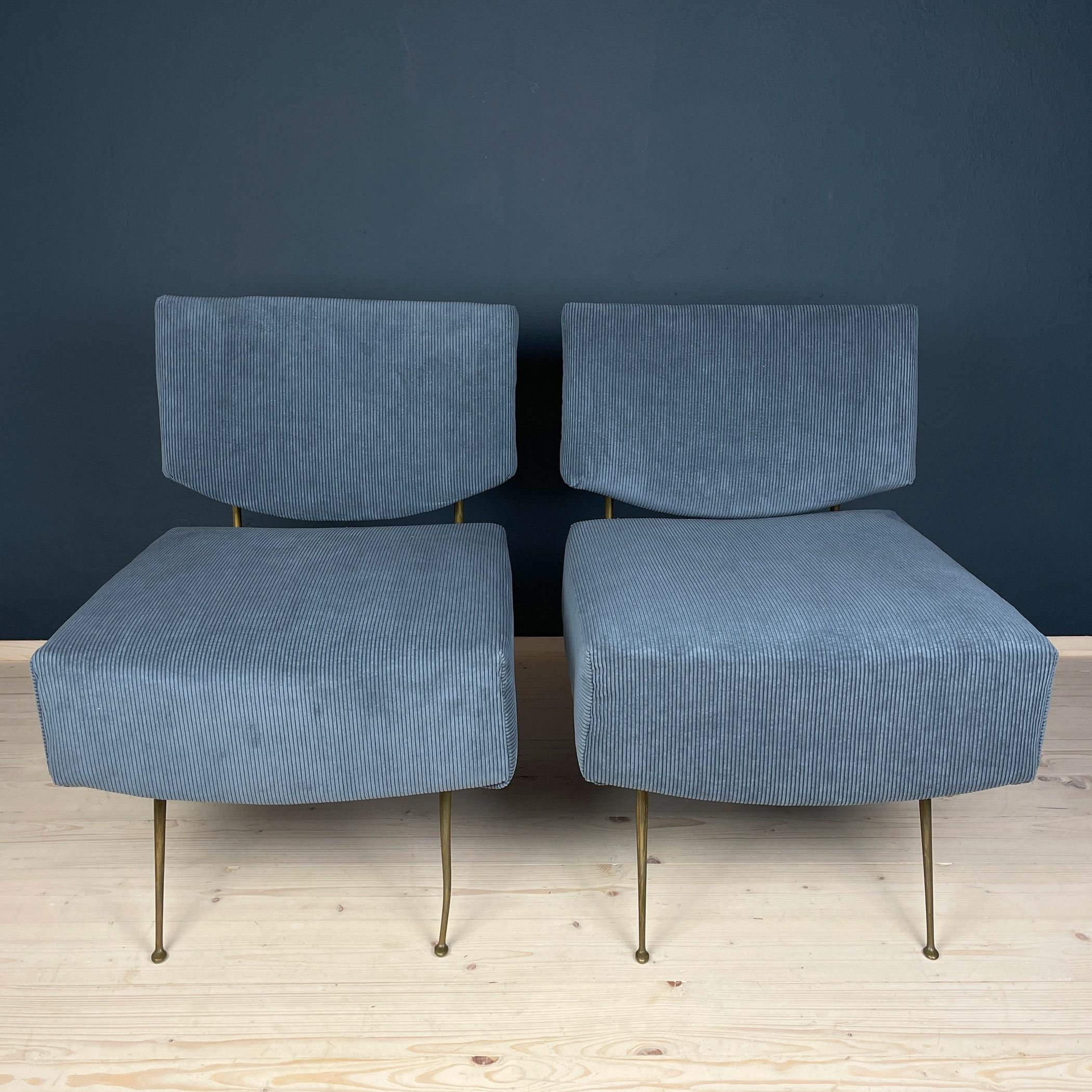 Introducing a remarkable pair of vintage lounge chairs from Italy, dating back to the 1950s. These exquisite pieces of Italian furniture effortlessly blend mid-century style with the comforts of home. Adorned in inviting blue corduroy fabric