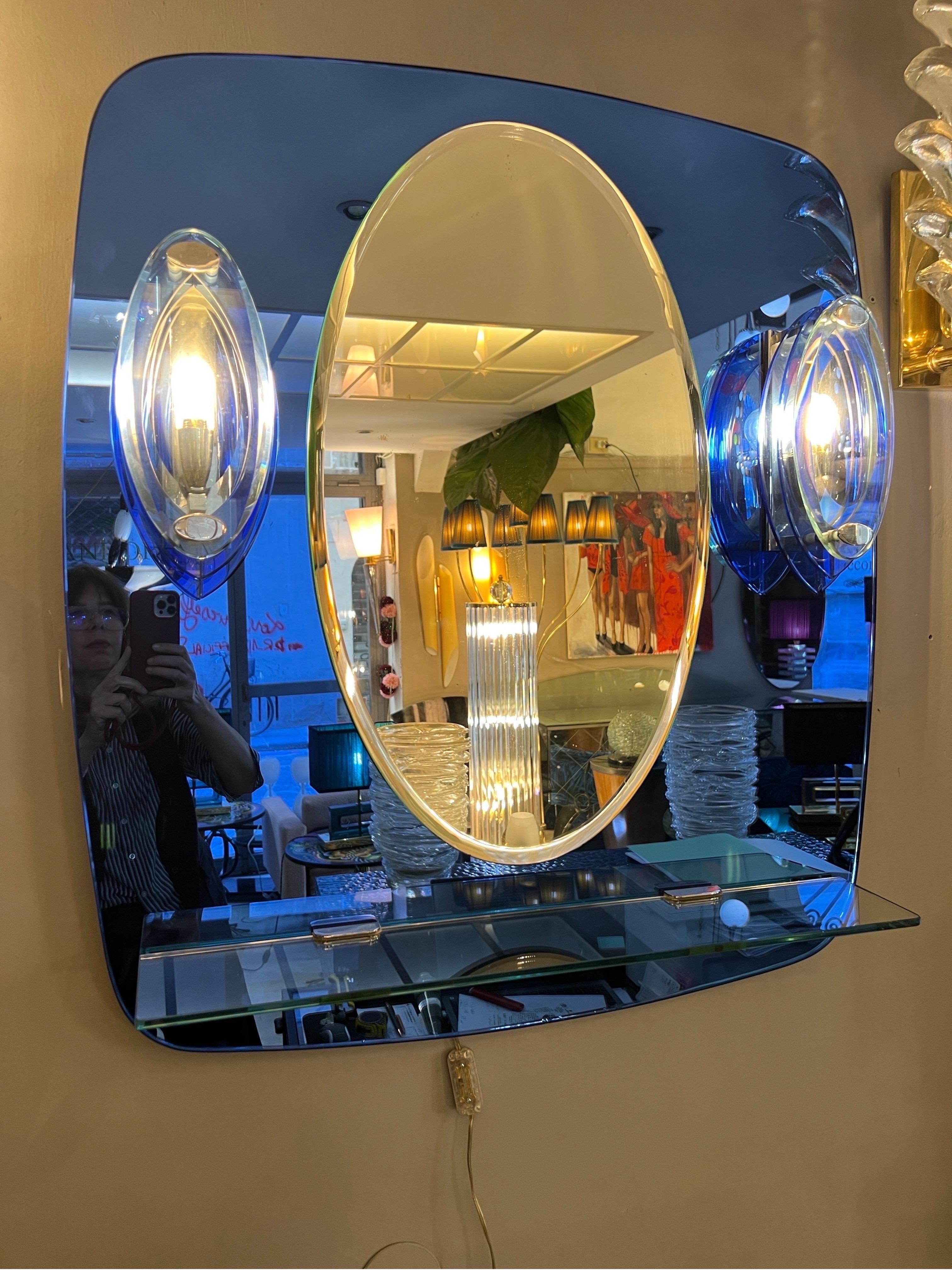 Vintage Blue Mirror with Sconces and shelf by Cristal Art, Turin Italy. 
Crystal shelf and chrome fittings.
Good vintage condition, there are some oxidations, normal sign of age and some small dents on the bottom of the mirror (please see the last