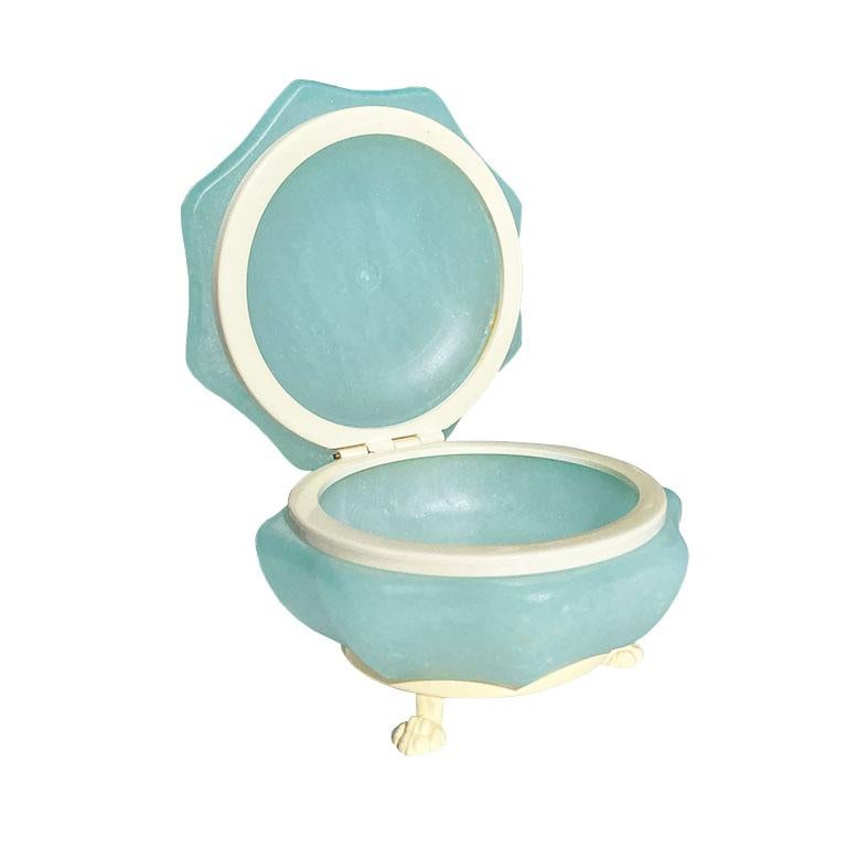 Blue opaline never looked so chic. This glass trinket box with a hinged lid will bring a hint of color to any space. The octagonal top is smooth and domed in shape. It opens to reveal a round interior with a yellow protective rim. The piece sits