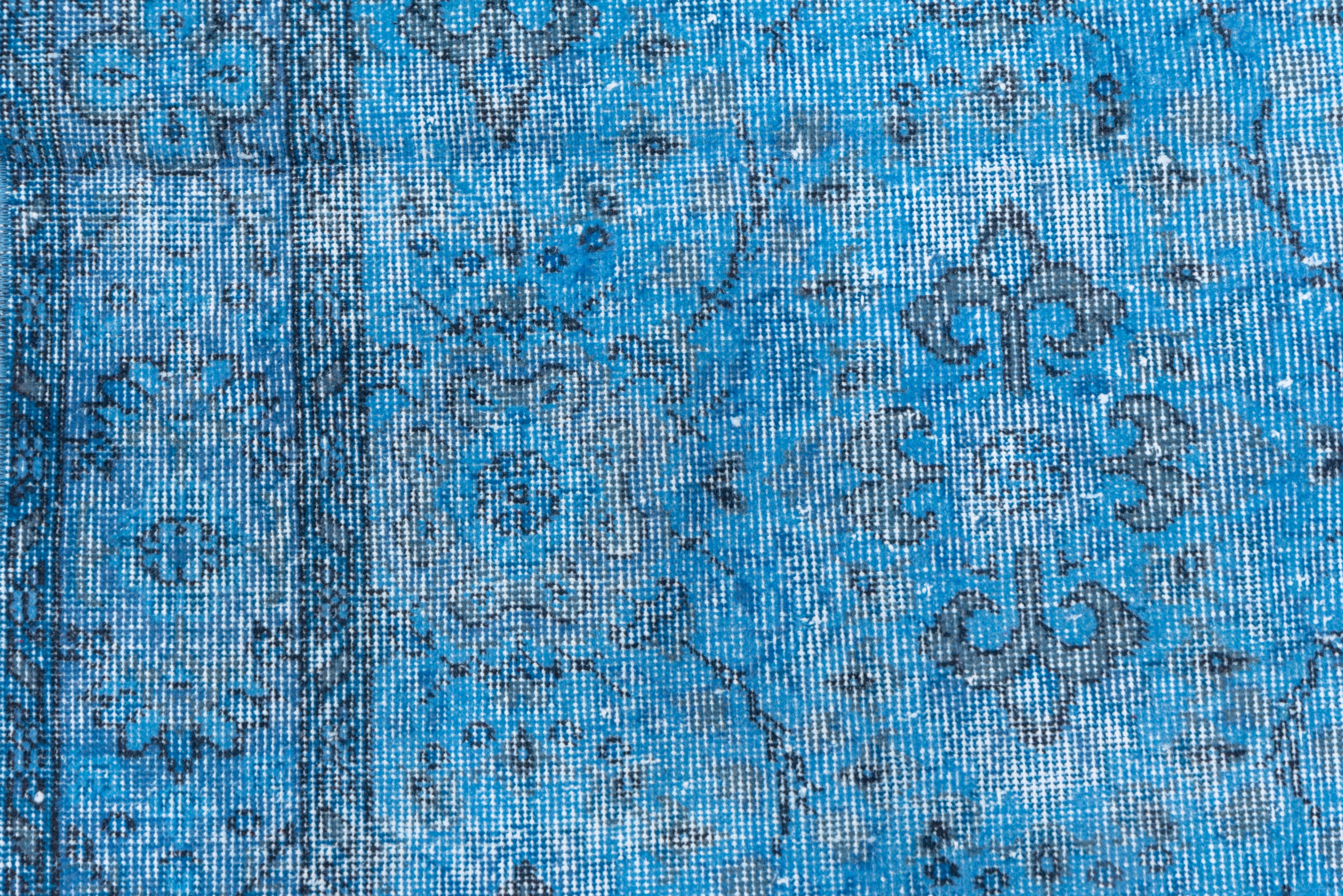 This blue Turkish overdye carpet has a pattern defined by the wear beyond the all-over general distress. Vertical and horizontal off white strips cross near the center. Shabby chic conditions and can offer some great texture for floor covering.
  