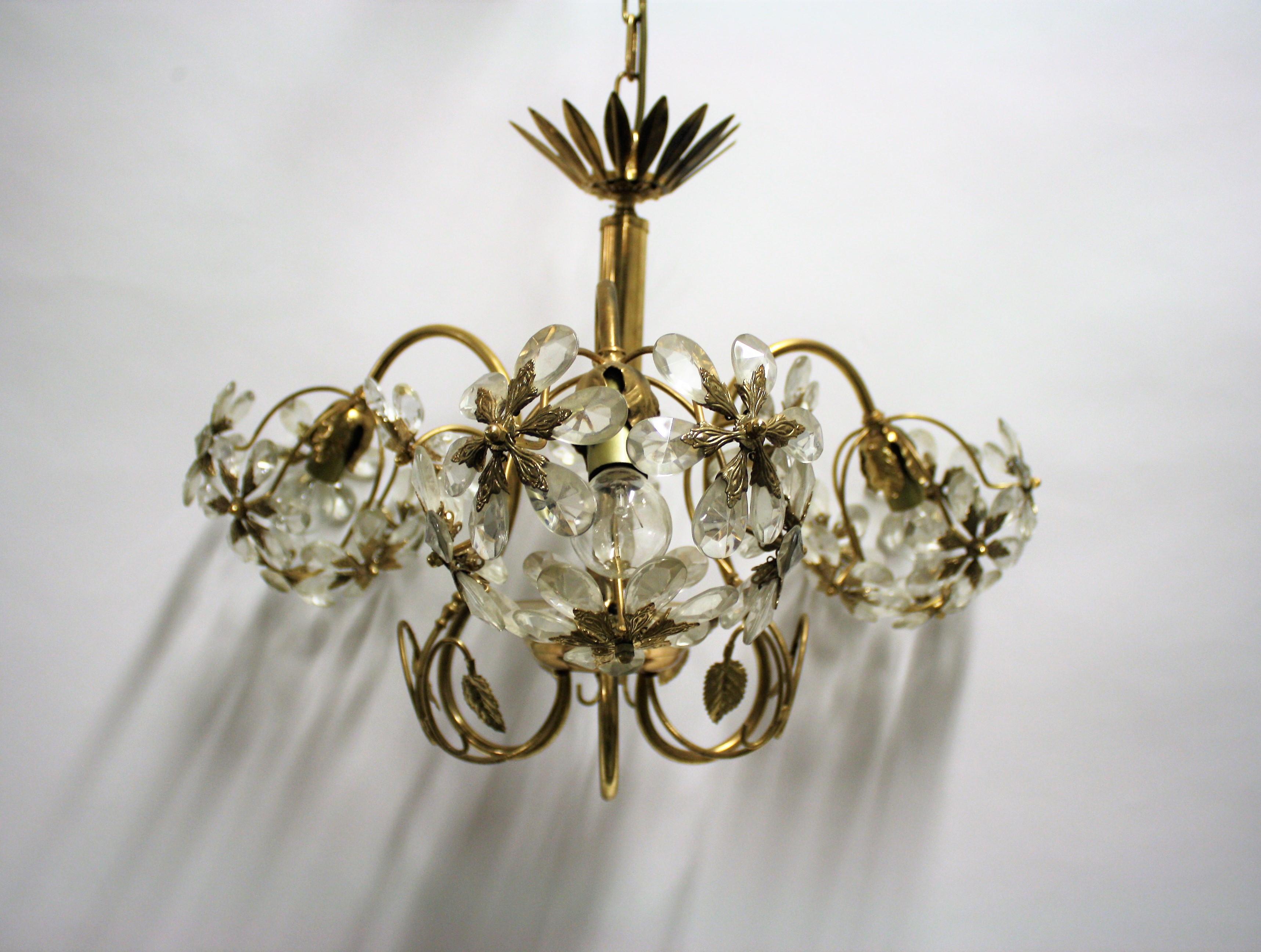 Vintage brass chandelier with glass decorations.

The chandelier consist of three arms with E26/E27 light bulb holders.

The chandelier is slightly patinated, 

1970s, Belgium

Dimensions:
Height: 42 cm/16” (without chain, chain height