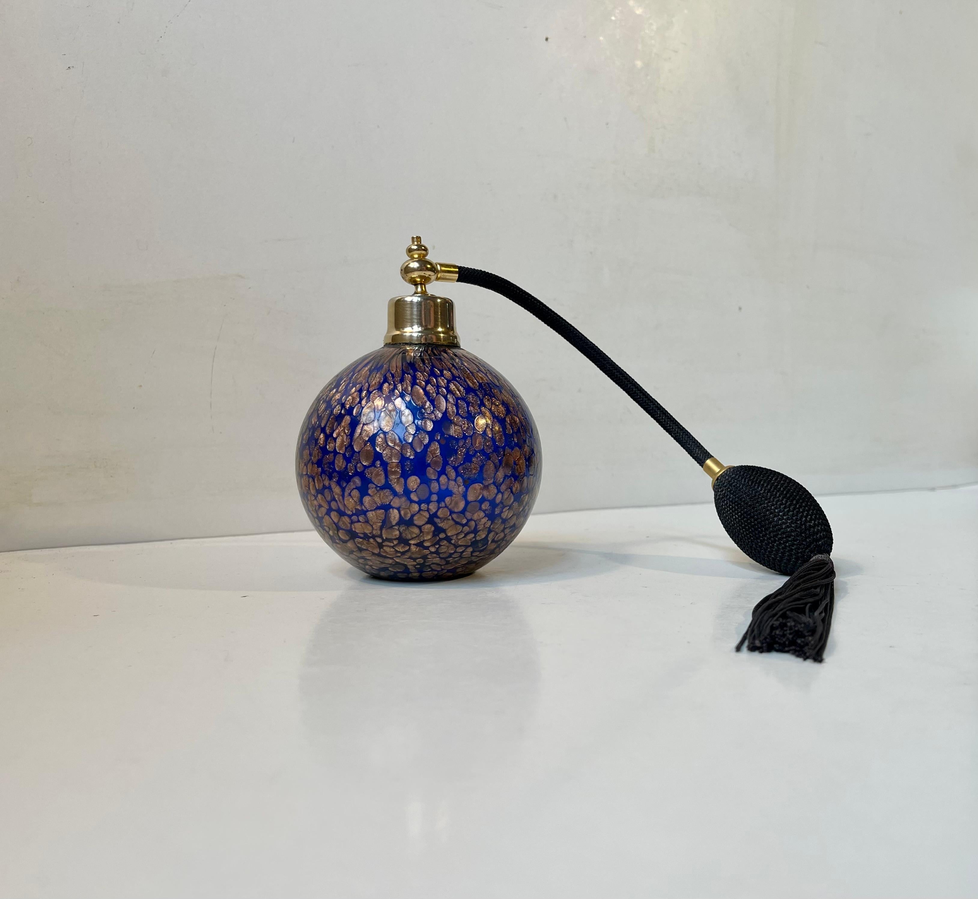 A spherical perfume flacon in cobalt blue murano glass decorated with gold flecks. Its in working order and complete. This object does not contain any perfume but is refillable.
Measurements: H: 12,5 cm, Diameter: 10 cm. Sprayer/ornament length: 30