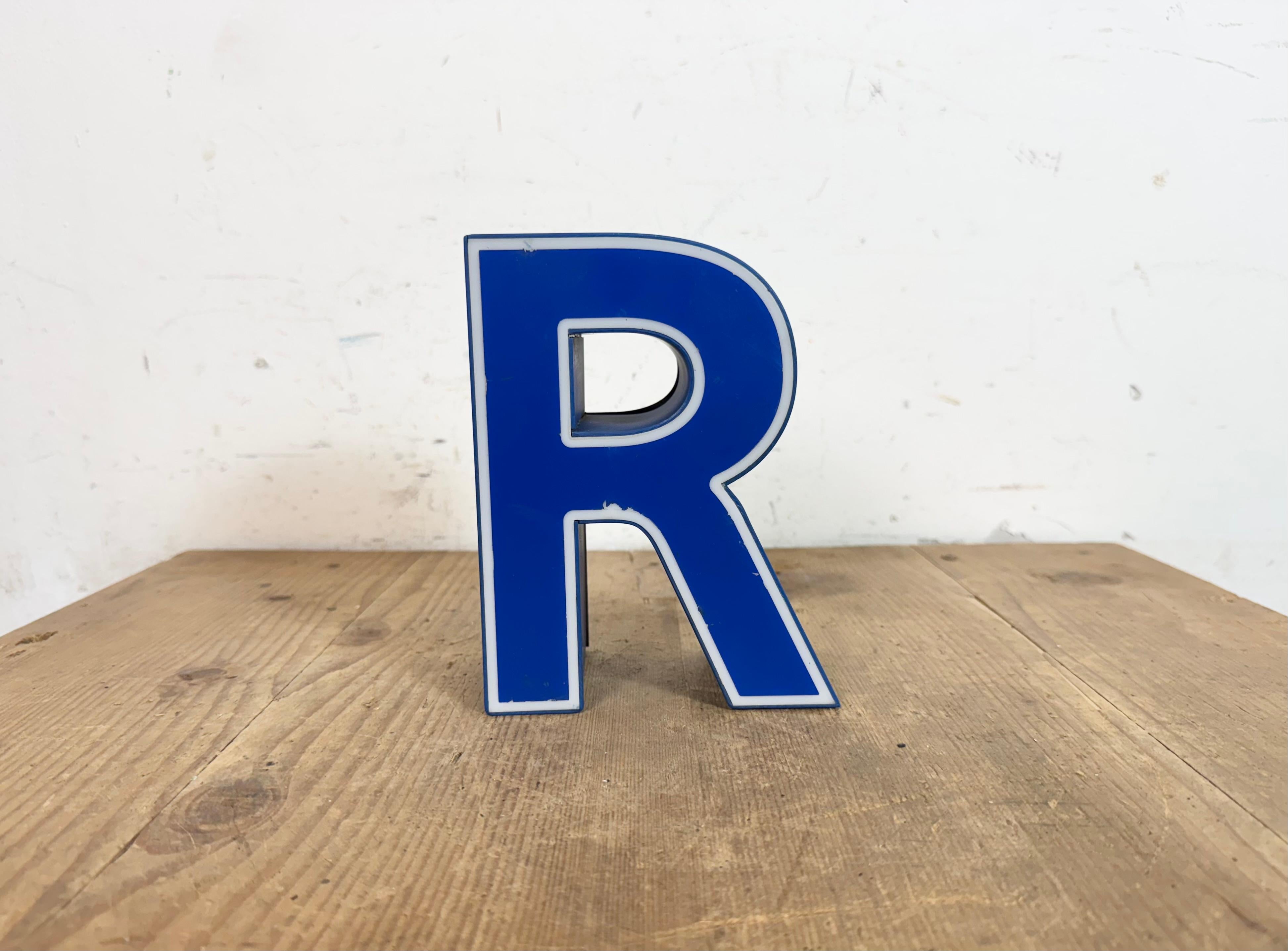 Esta letra R iluminada de plástico azul industrial vintage se fabricó en Italia en los años 70 y procede de un antiguo cartel publicitario. Está equipado con una tira de LED. La letra puede utilizarse como lámpara de mesa o aplique de pared.El peso