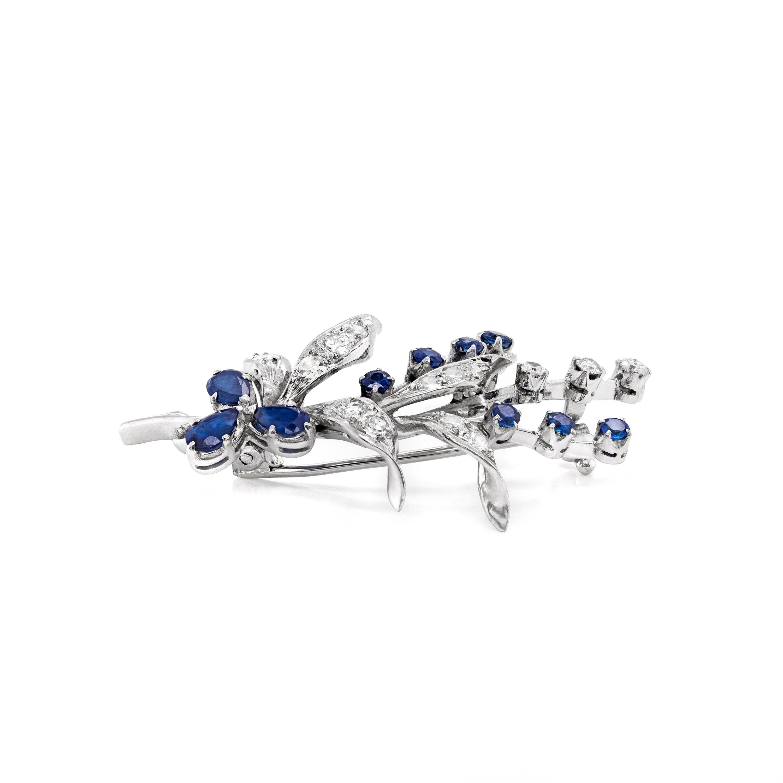 This 1960's floral spray brooch is beautifully designed with a mix of deep blue sapphires and fine quality diamonds for a really wonderful contrast. The piece consists of three pear shaped sapphires and seven round cut sapphires totaling to