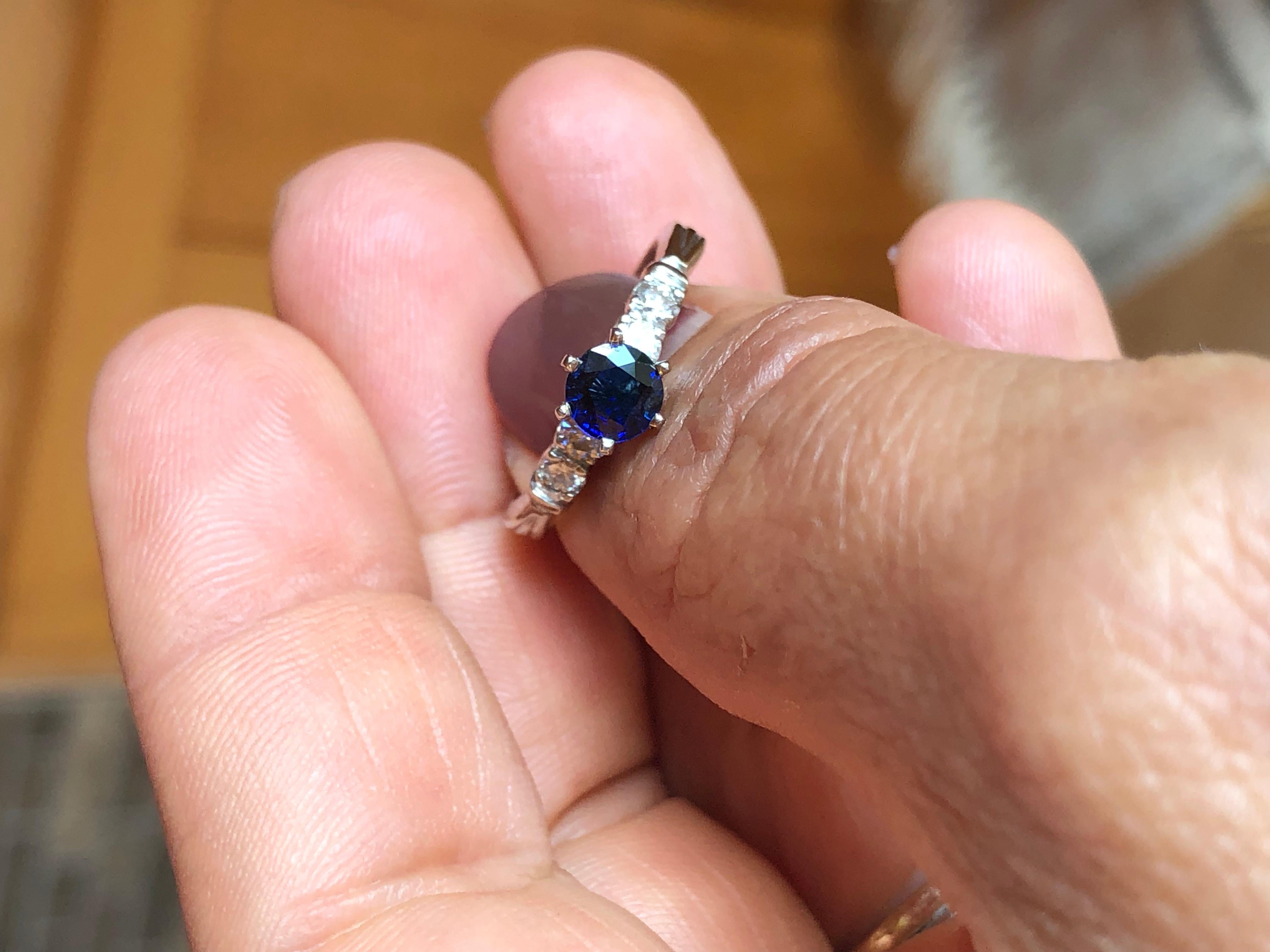 This is a lovely vintage 1 carat royal blue sapphire and diamond 14K white gold engagement ring. It has a great design and holds Approx. 0.65 carat, royal blue sapphire round cut in the center and four round brilliant cut diamonds G-H/SI1, totaling