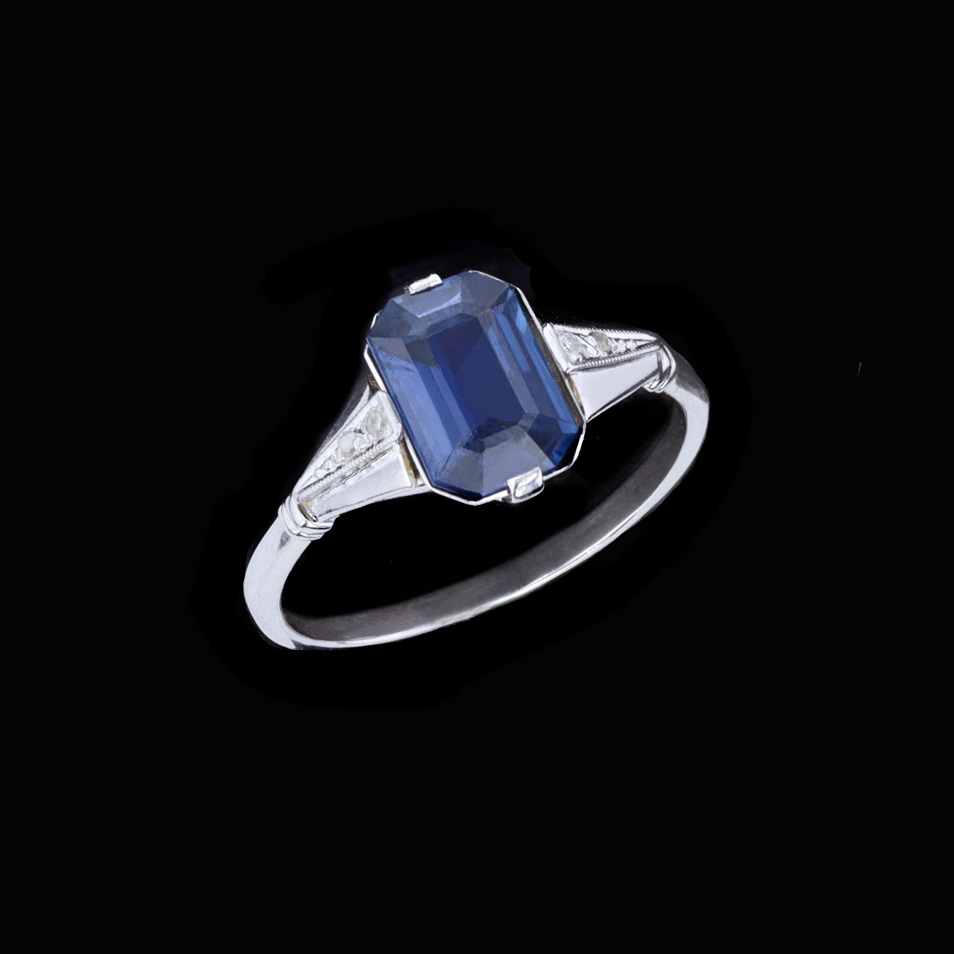 Centered with an emerald cut sapphire and flanked by a pair of round diamonds, this ring is a statement piece for the true romantic. The three stone ring features an Emerald Cut Sapphire weighing 1.79CT ctw And 2 Round Diamonds weighing 0.04TWT ctw.