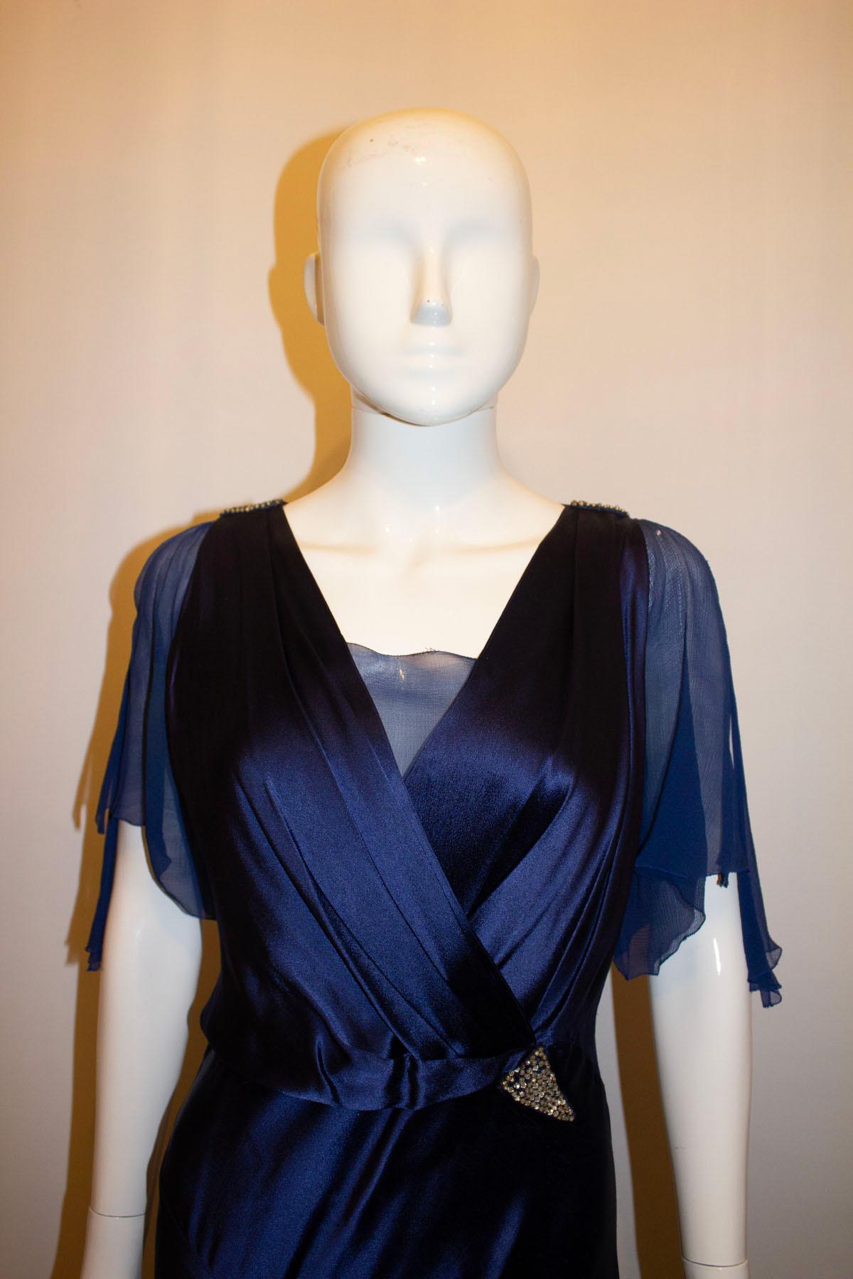 A stunning vintage evening gown by British firm Marshall and Snelgrove. The dress is in a royal blue satin and with a silk v insert at the front and back. It has silk chiffon cap sleaves. Measurements: Bust 38'' , length 60''