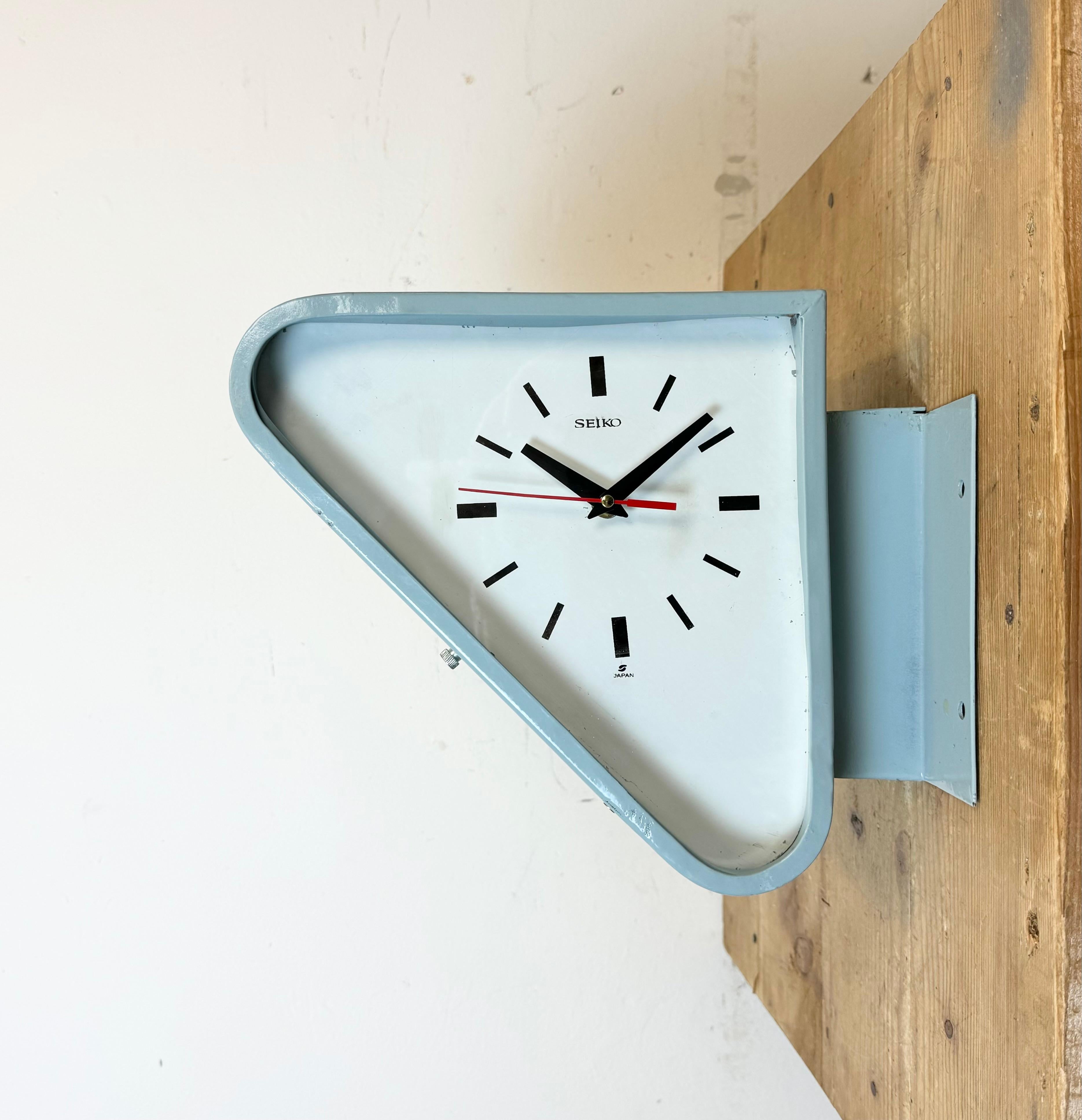 Vintage Industrial triangle Seiko navy slave clock made in Japan during the 1970s. These clocks were used on large tankers and cargo ships. It features a light blue metal body, a metal dials and a clear glass covers. Former electric slave clock has