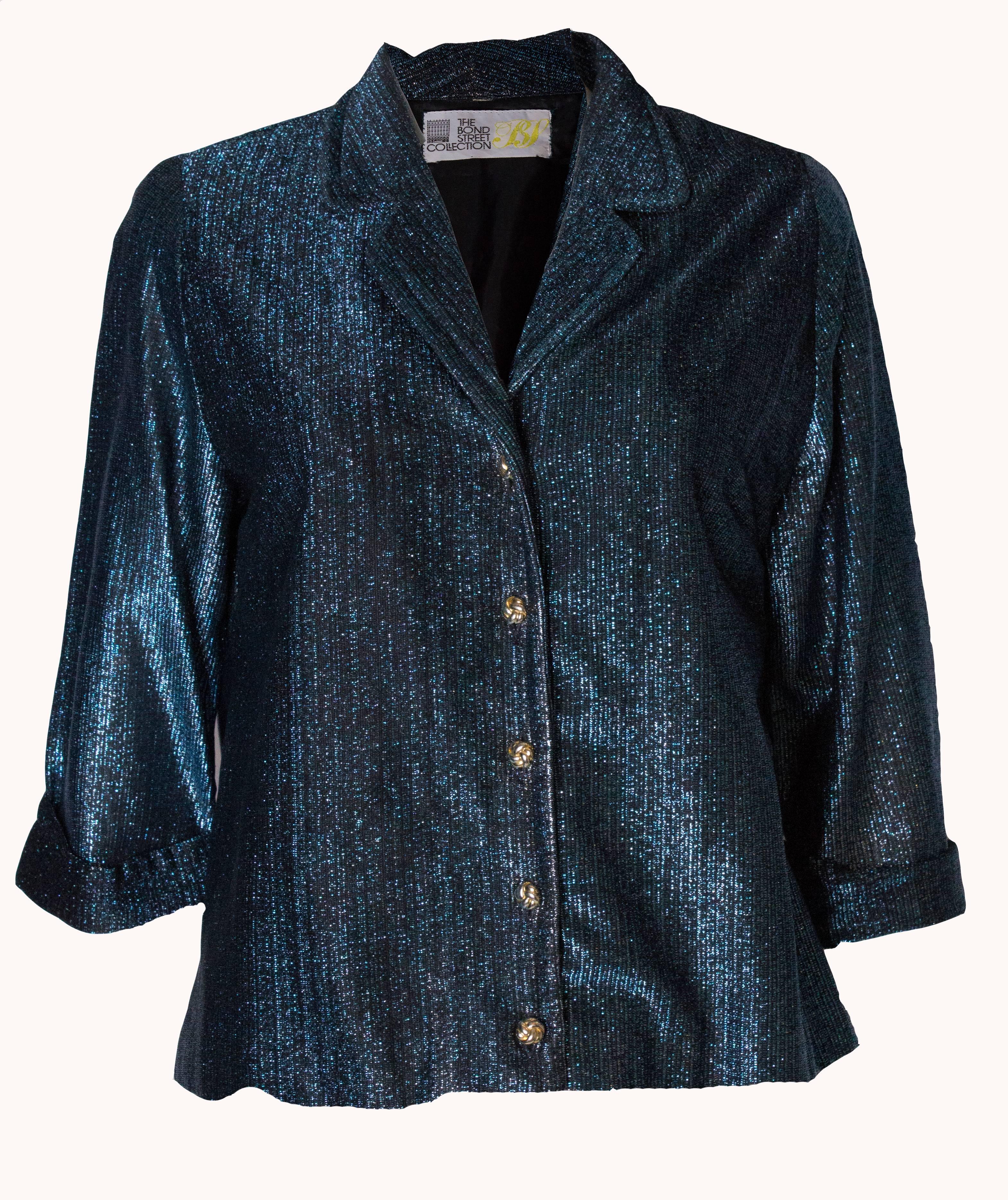 An easy to wear blue sparlkly jacket by Bond Street Collection. The jacket has elbow length sleeves with a small turn up,and a five gold button opening at the front.