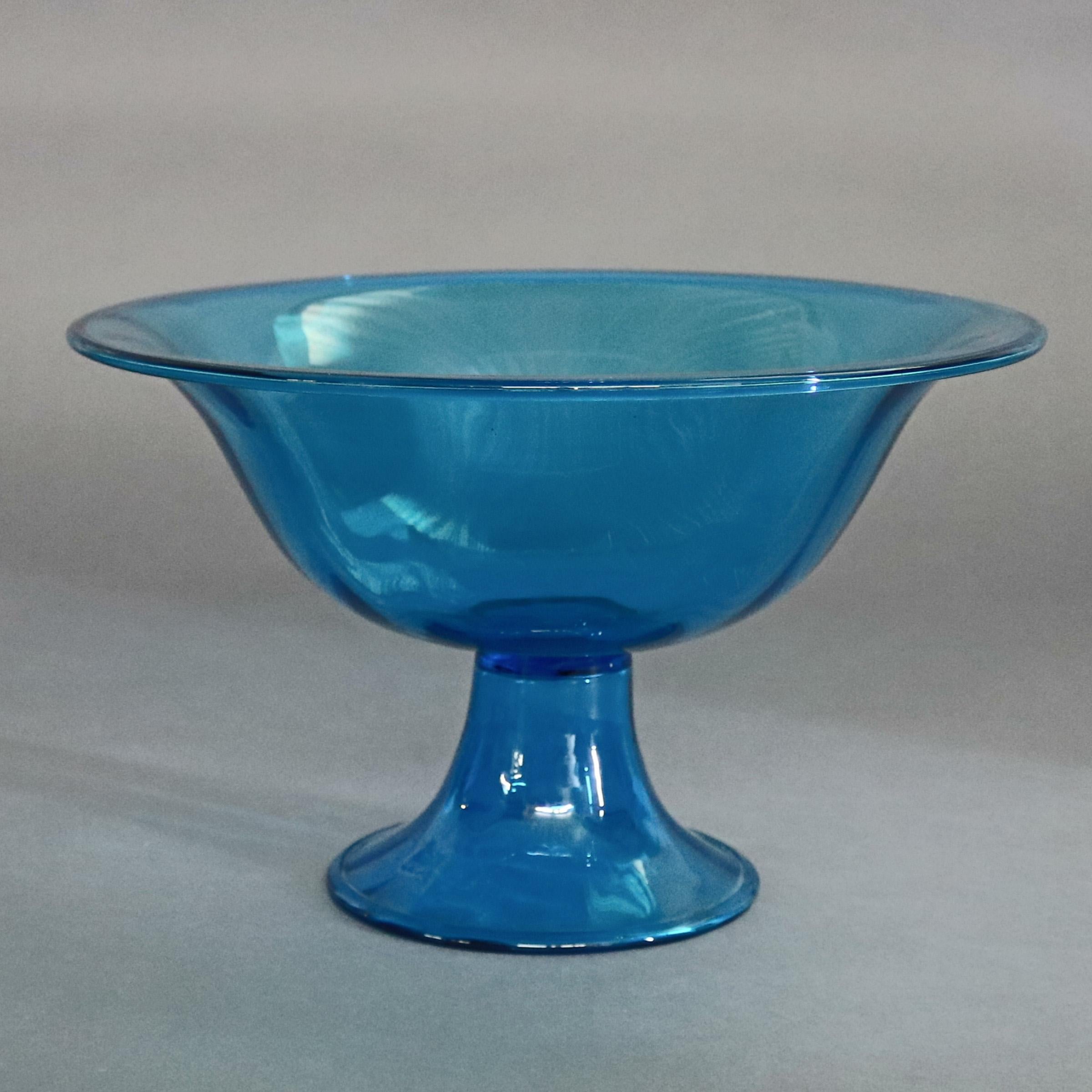 A vintage Steuben art glass center compote features blue glass with flared bowl surmounting bell pedestal, unsigned and illegible numbering, circa 1950.

Measures - 8” h x 13”diam rim, 4.25” diam base