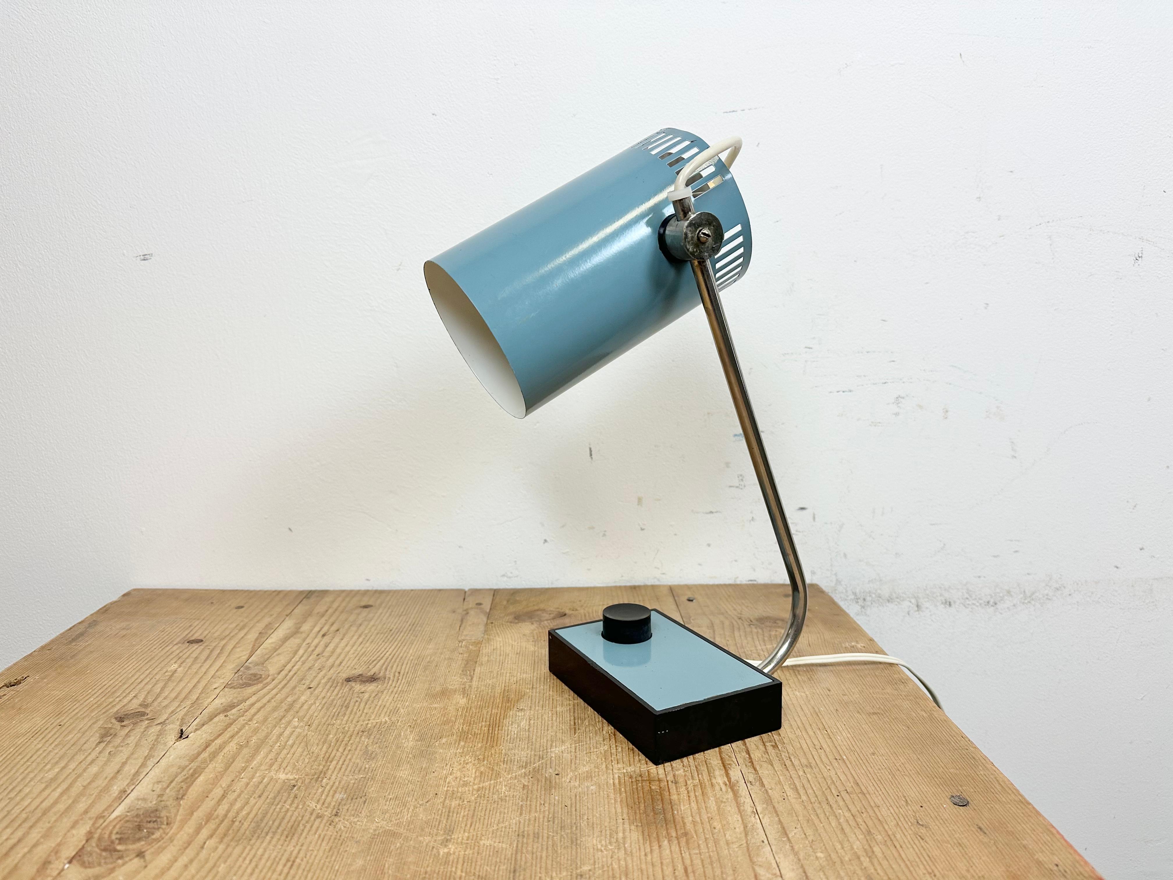 Vintage blue table lamp made in former Czechoslovakia during the 1960s. It features a bakelite base with switch, a blue metal adjustable shade and chrome plated arm. The original socket requires E 27/ E26 light bulbs. The weight of the lamp is 0,8