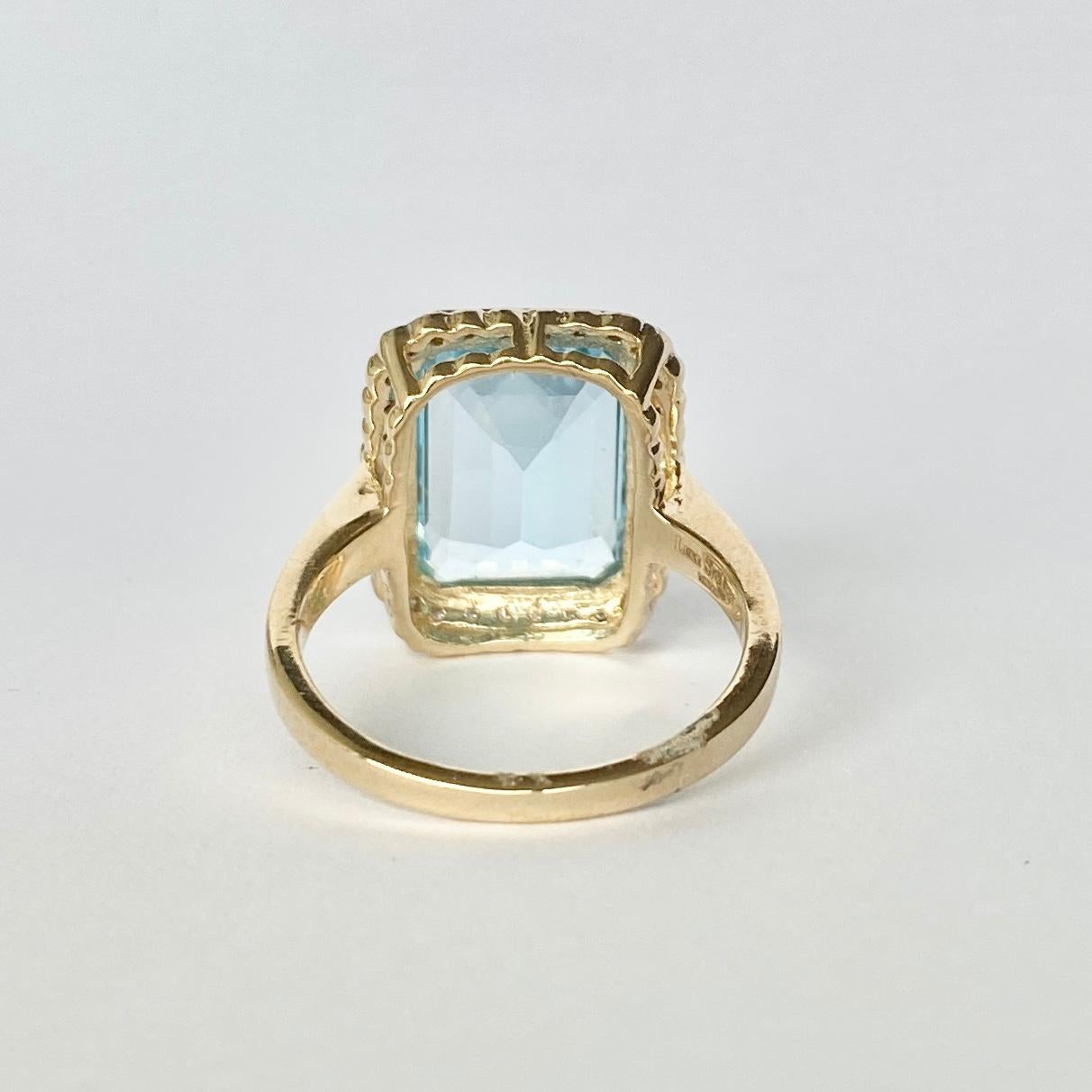 What a show stopper! The bright blue topaz is emerald cut and reflects the light beautifully and shows off the colour of the stone. It has a halo of diamonds surrounding it totalling 35pts. 

Ring Size: N 1/2 or 7 
Stone Dimensions: 14x10mm 
Height