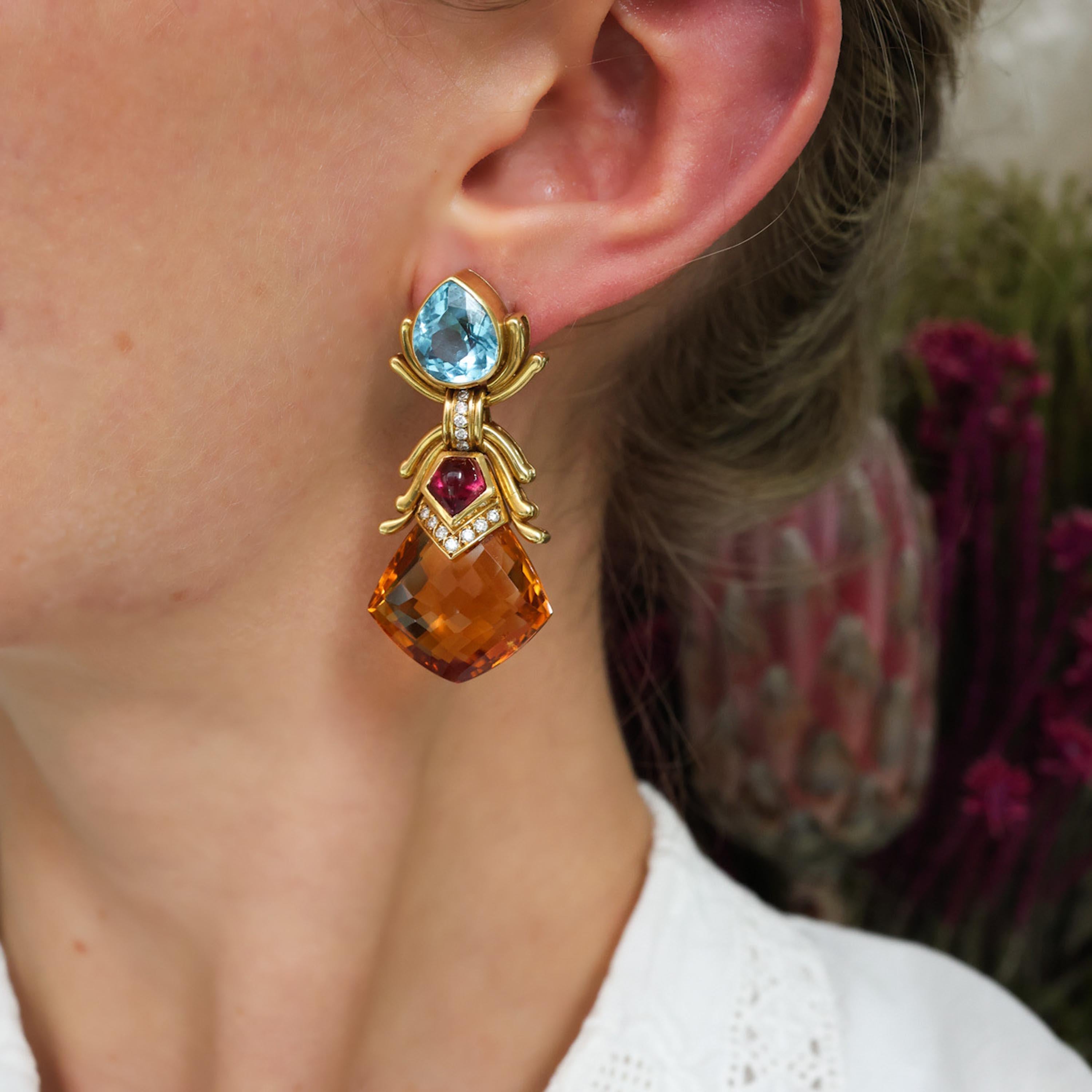A pair of vintage multi gem drop earrings, with pear shape blue topaz, in each, in a rub over setting with gold decoration below, onto a round brilliant-cut diamond set link, connecting a pendant, set with a pentagonal, cabochon-cut pink tourmaline,