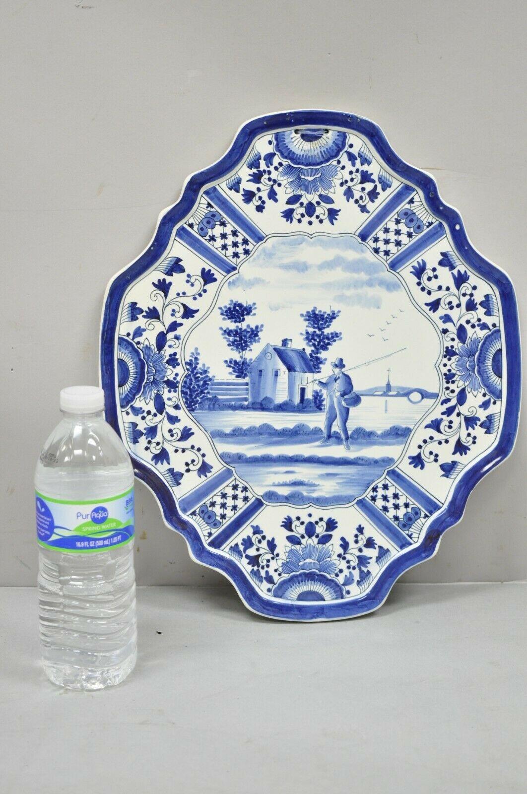 Vintage blue white Porcelain Delf style Italian fisherman wall art charger plate. Item features central fisherman design, scalloped edge, holes for wall hanging, markings to rear, great style and form. Circa mid 20th century. Measurements: 14.5