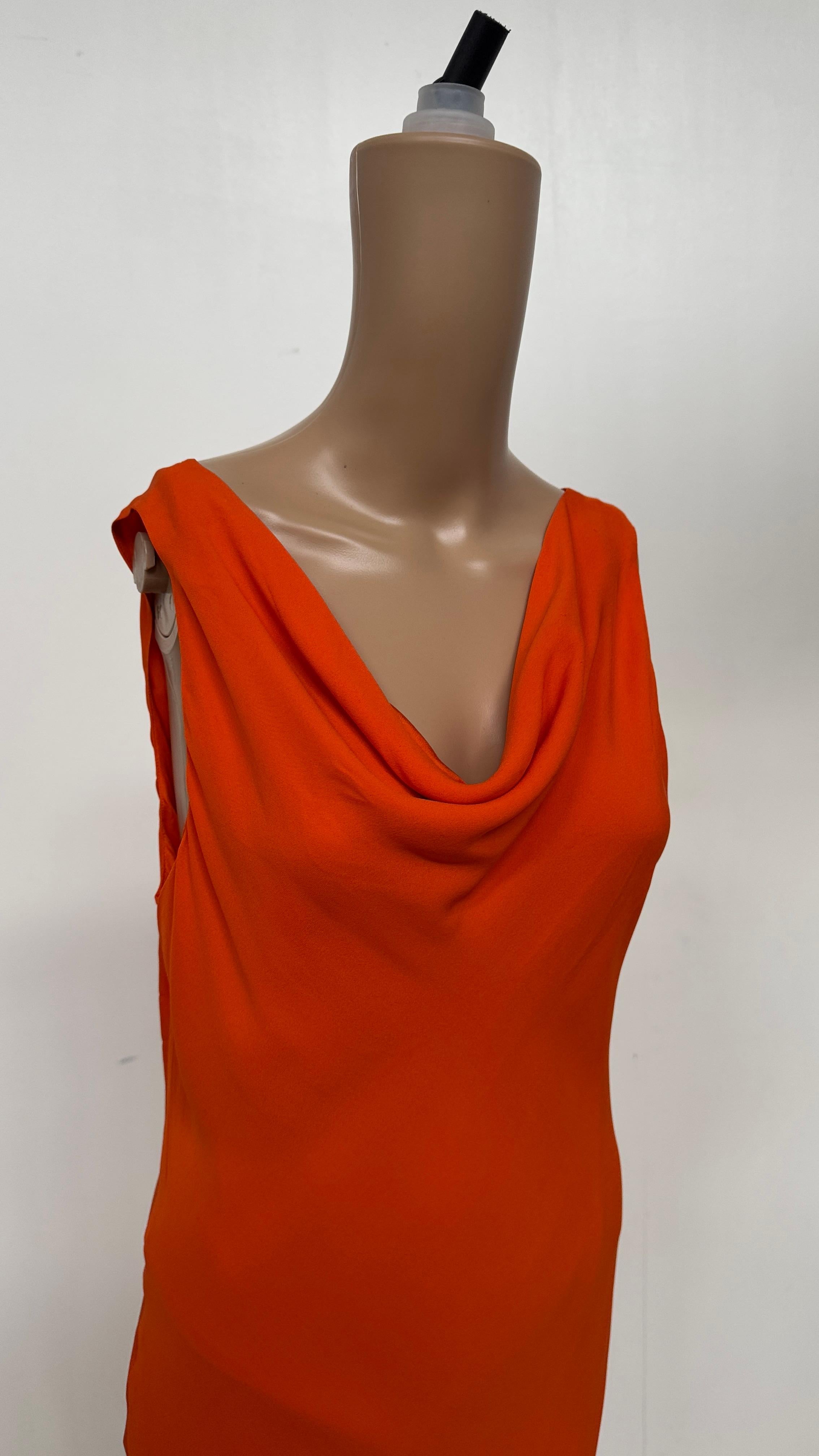 This captivating vintage slip dress by Blunauta embodies the refined sensuality and effortless elegance that defined Italian fashion in the 1990s. Crafted from pure silk in a bold, vibrant orange tone, the dress showcases the brand’s signature